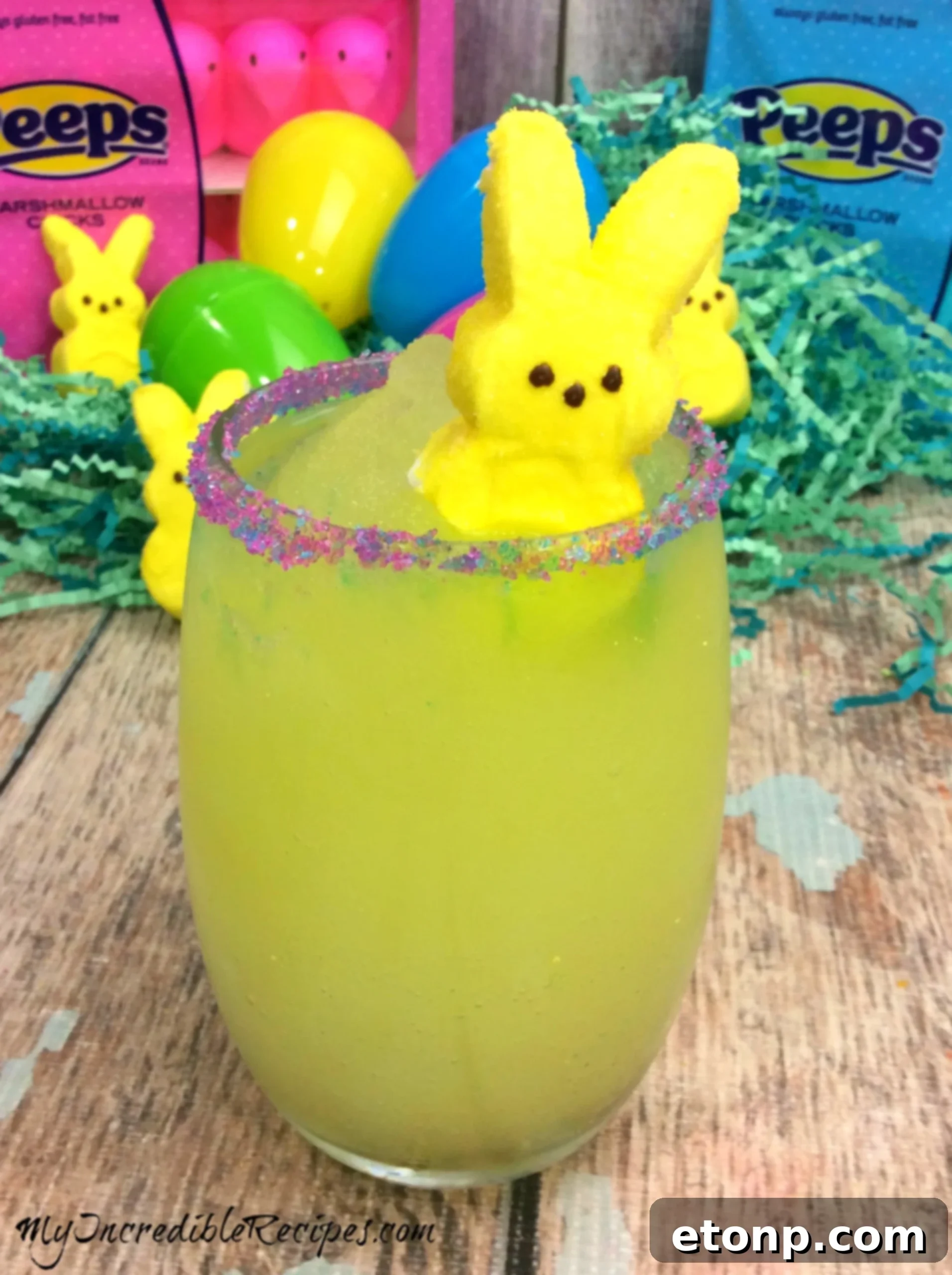 Beautiful blue Naughty Peep Cocktail with a pink sugared rim and yellow Peep garnish