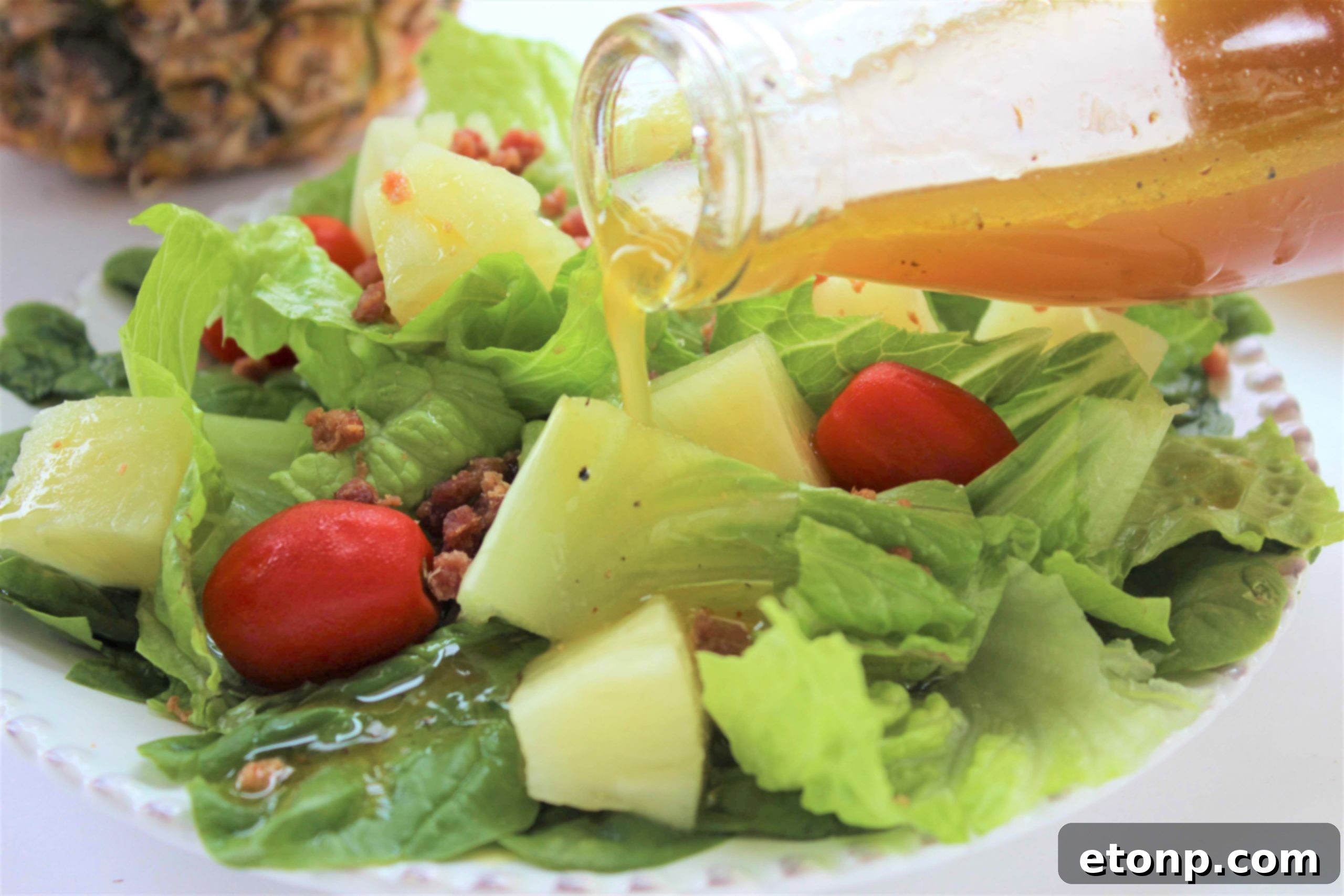 A vibrant green salad generously dressed with Pineapple Vinaigrette