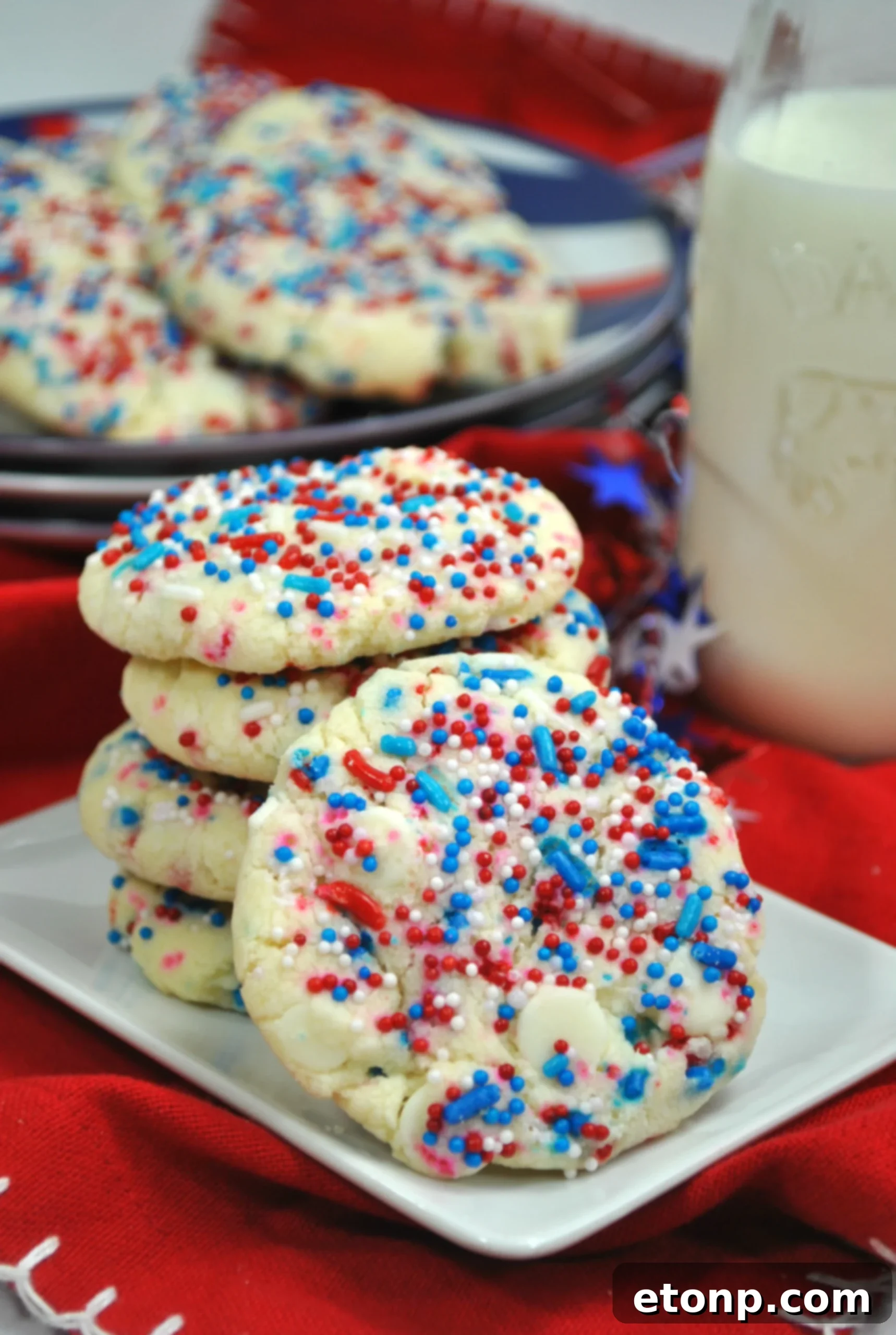 Close-up of freshly baked White Chocolate Firework Cookies with red, white, and blue sprinkles on a cooling rack.