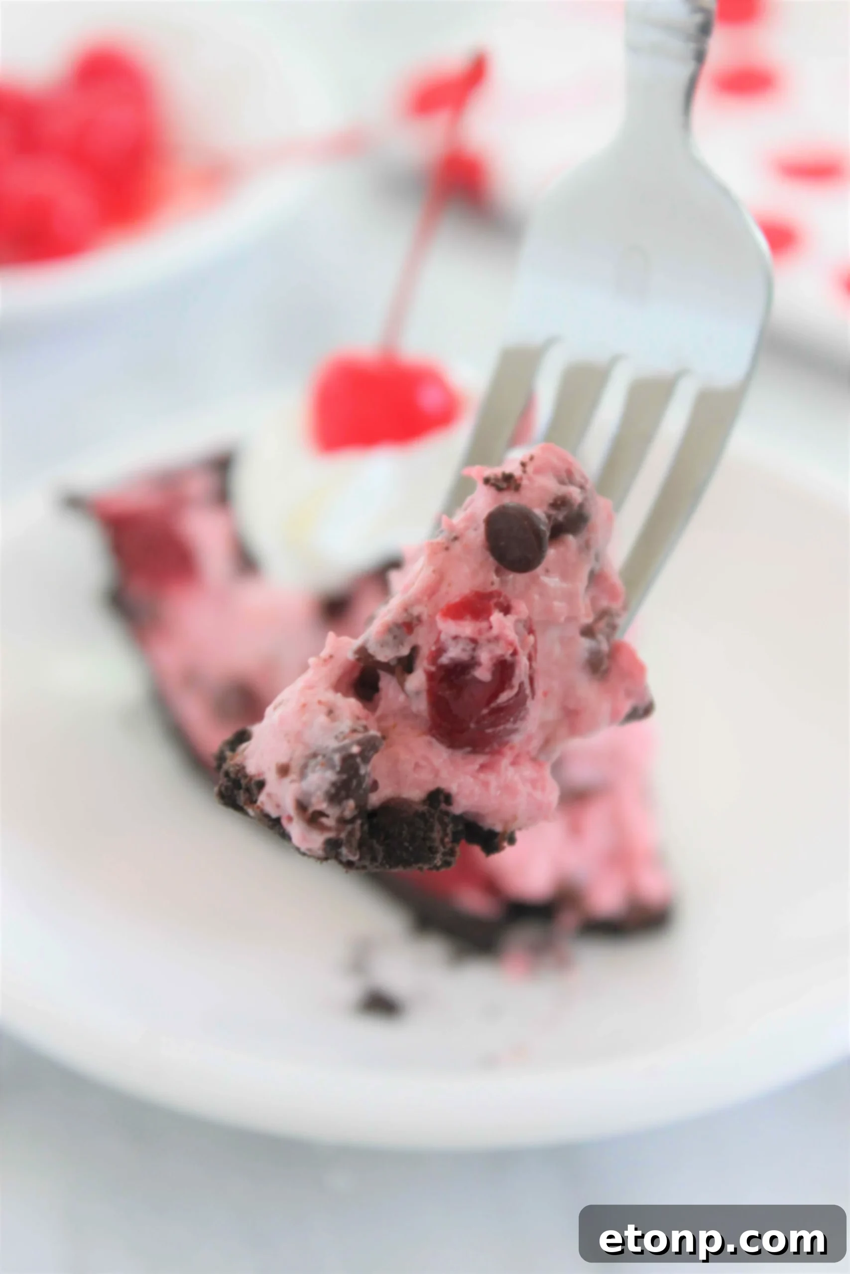 A close-up of a single slice of the No-Bake Cherry Chocolate Chip Dreamsicle Pie, showing the layers and creamy texture.