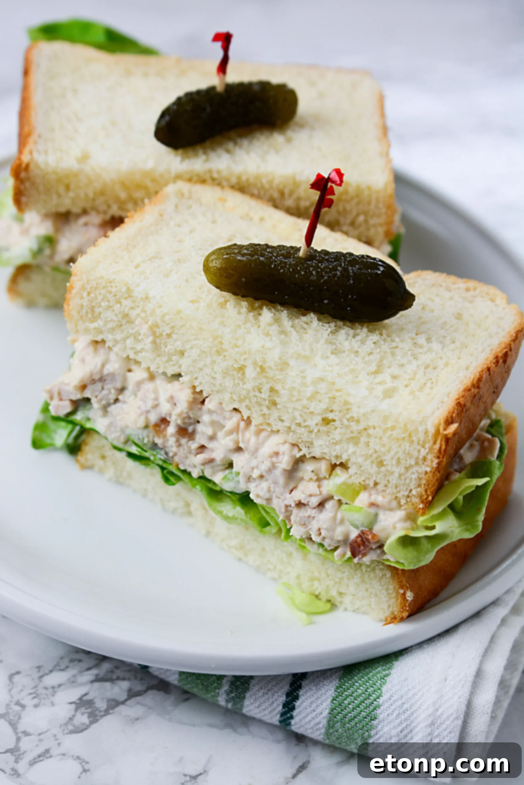 The Ultimate Chicken Salad 4 A serving of chicken salad on a sandwich with lettuce and tomato.