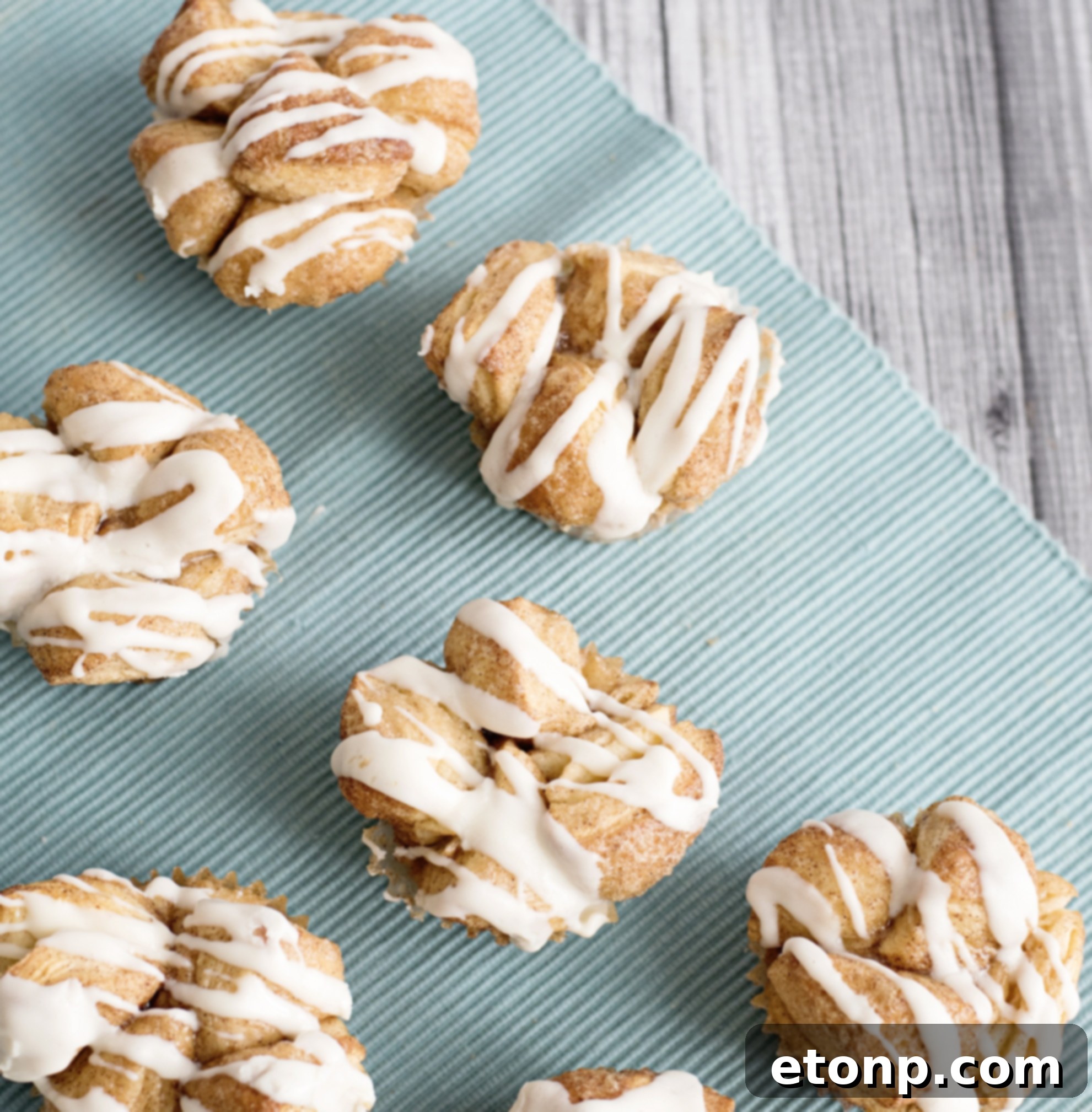 Baked Snickerdoodle Monkey Bread Muffins in a muffin pan, golden brown and ready for frosting.