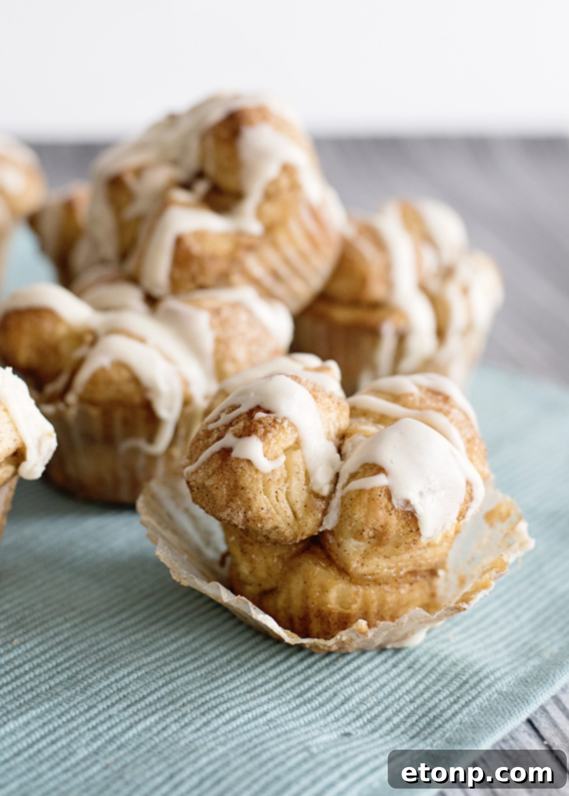 A finished Snickerdoodle Monkey Bread Muffin being picked up from a cooling rack, showcasing its appeal and easy handling.