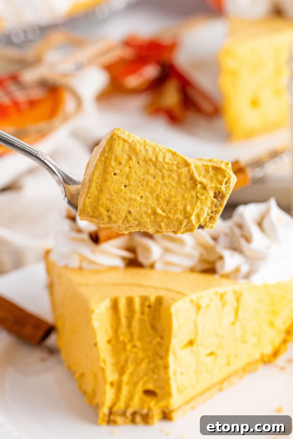 slice taken out of pumpkin cheesecake on plate