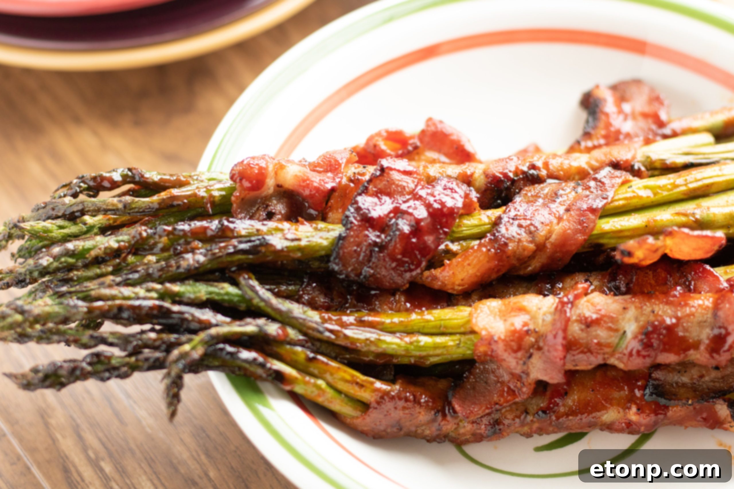 Delicious Brown Sugar Bacon Wrapped Asparagus bundles on a platter