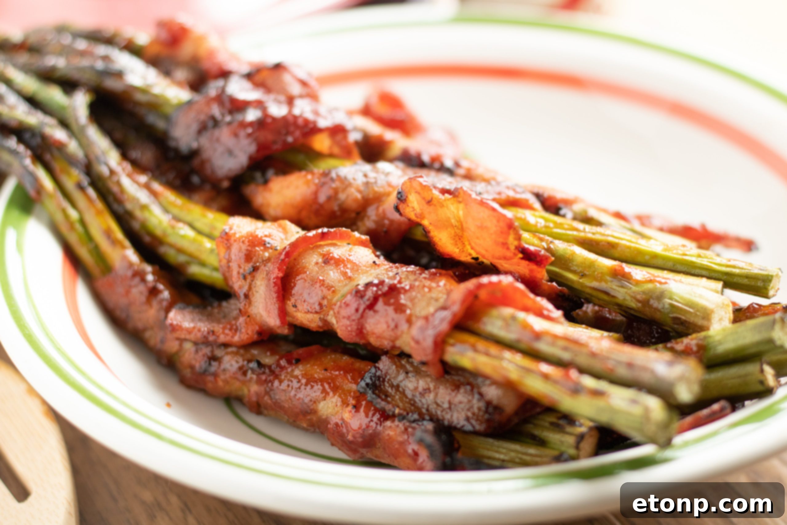 Close up of a single perfectly cooked bacon wrapped asparagus bundle