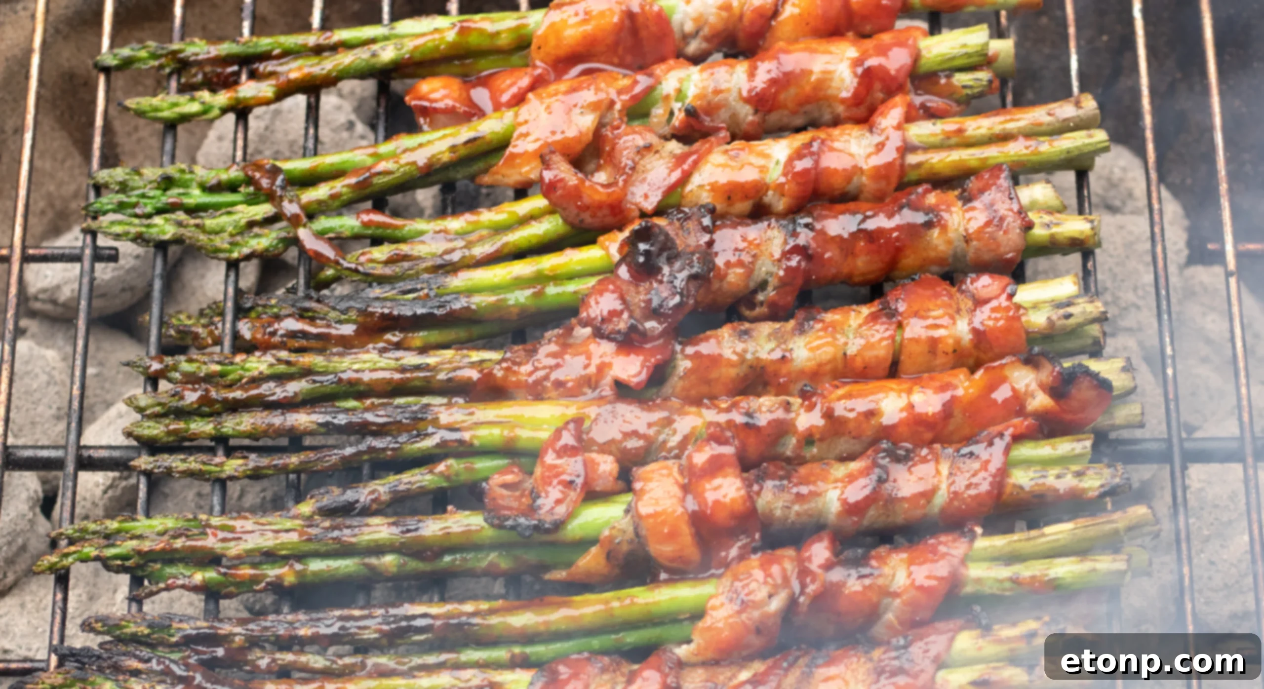 Bacon wrapped asparagus cooking on a grill