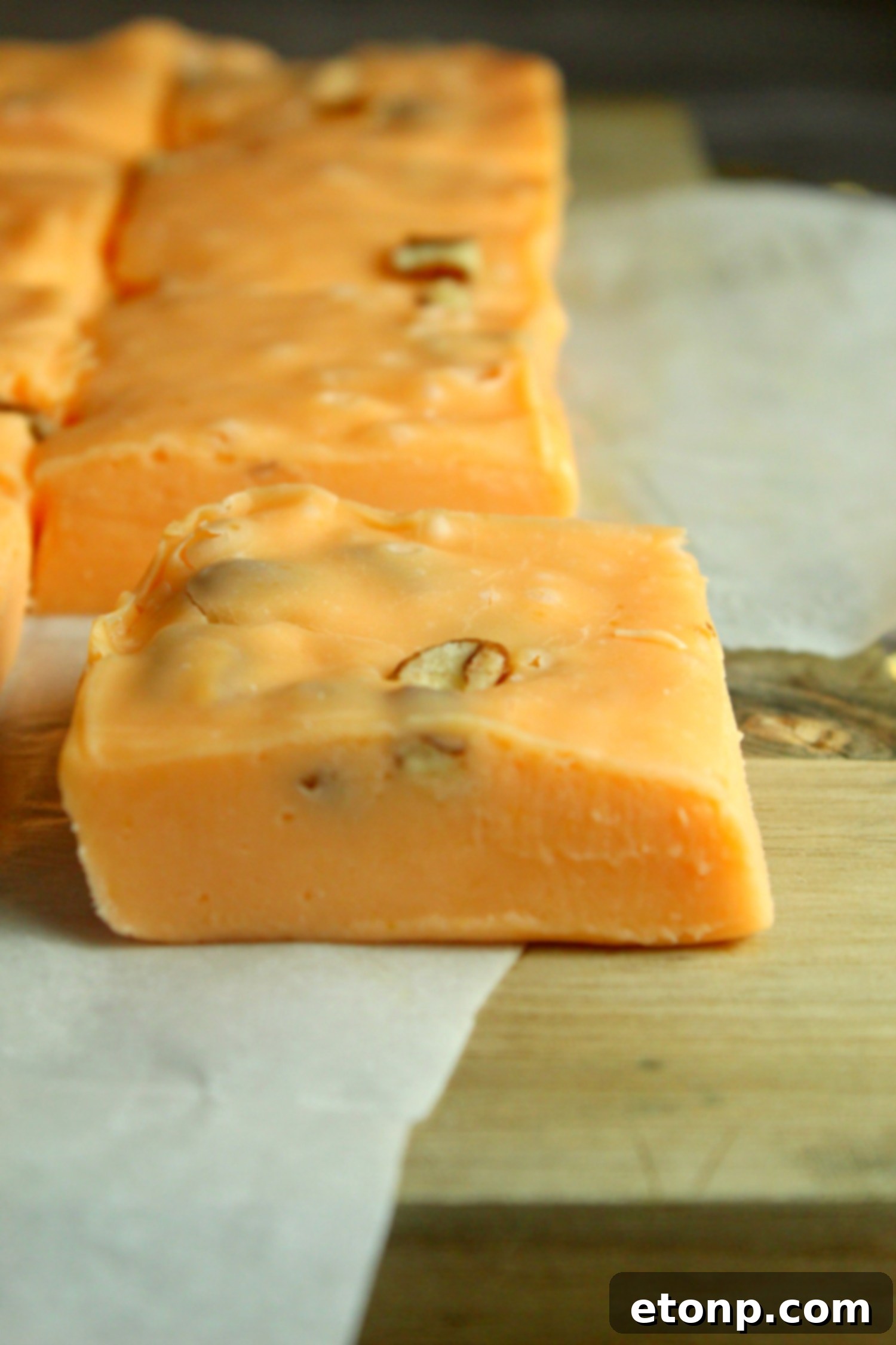 A collection of pumpkin fudge squares nestled in festive paper liners, ready to be enjoyed or gifted