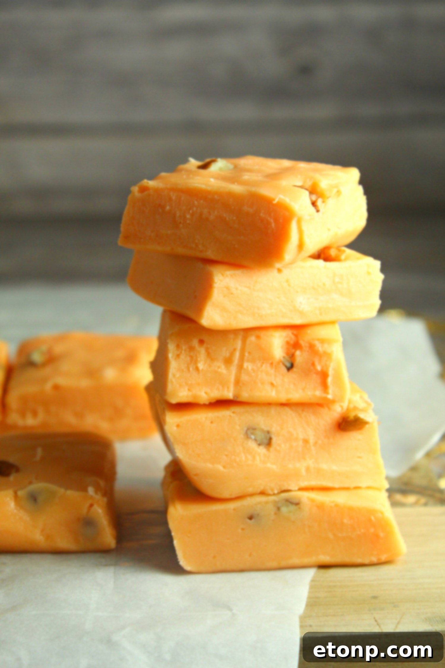 A close-up shot of pumpkin fudge, perfectly sliced, highlighting its creamy inside