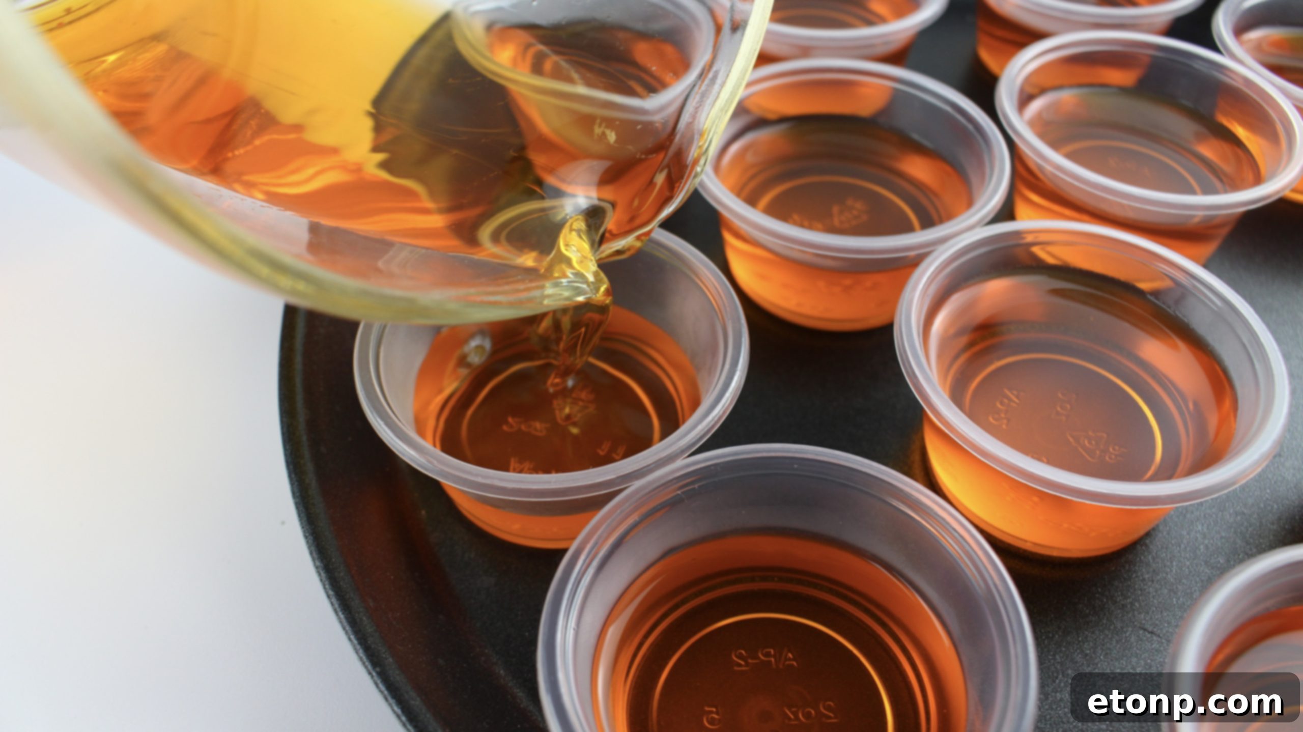 Overhead shot of Orange Creamsicle Jello Shots neatly arranged, showcasing their bright orange color and creamy toppings, ready for a party.