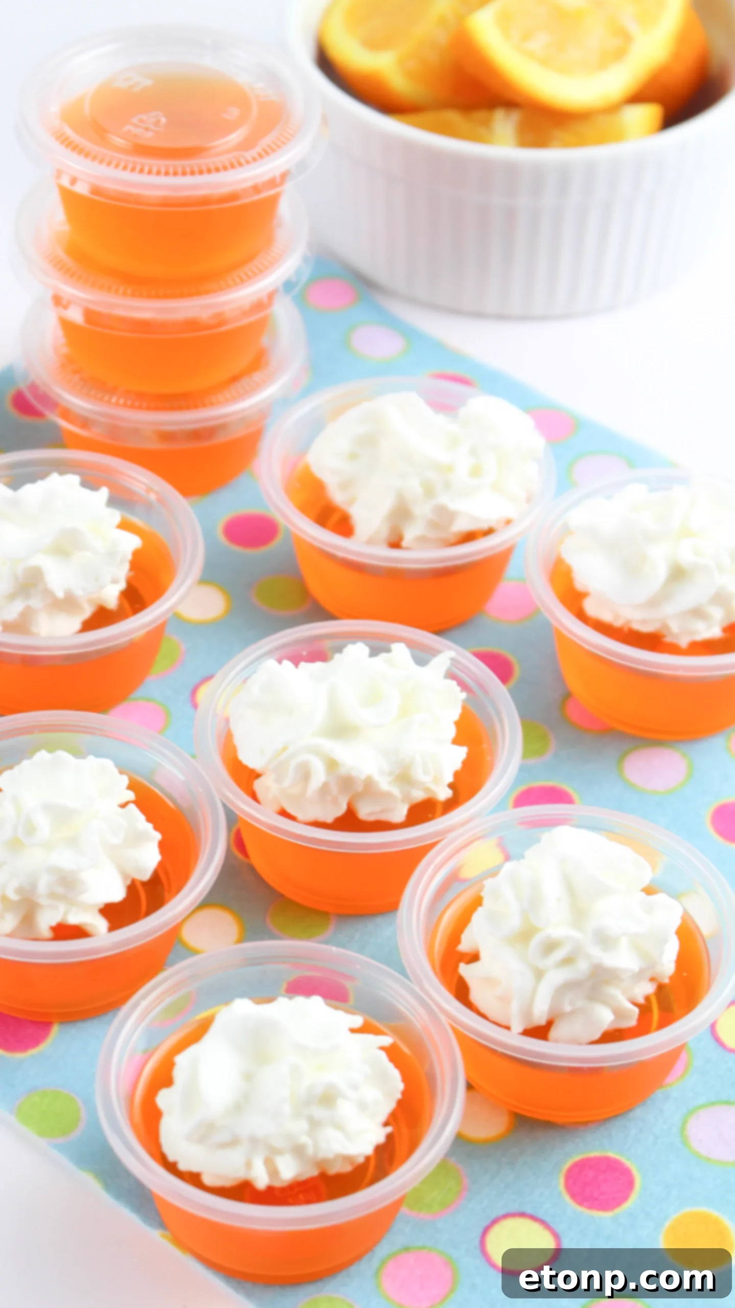 A collection of Orange Creamsicle Jello Shots with lids, indicating they are ready for storage or transport, ideal for pre-party prep.
