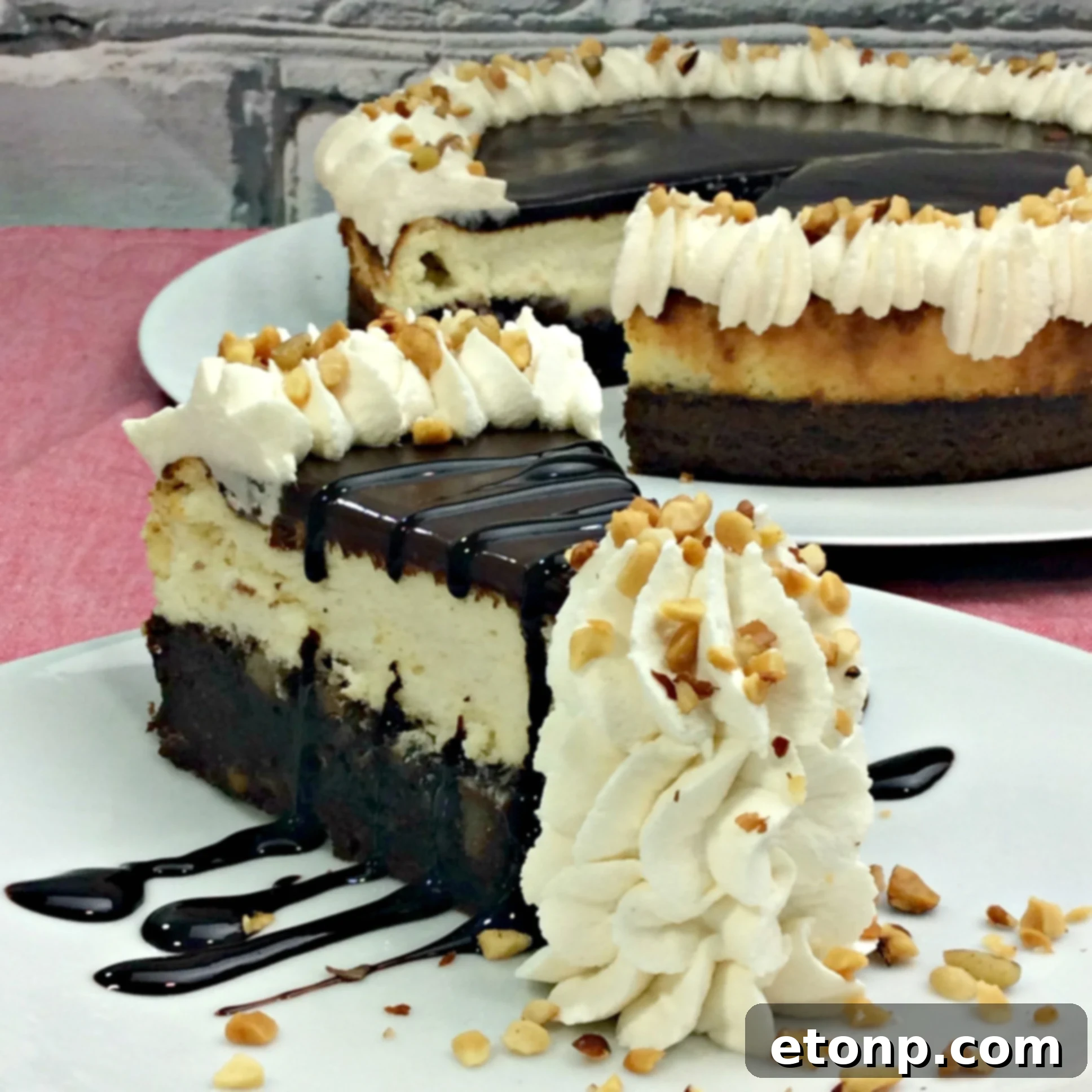 A close-up of the Hot Fudge Sundae Brownie Cheesecake, showing the irresistible combination of ganache, whipped cream, and nuts