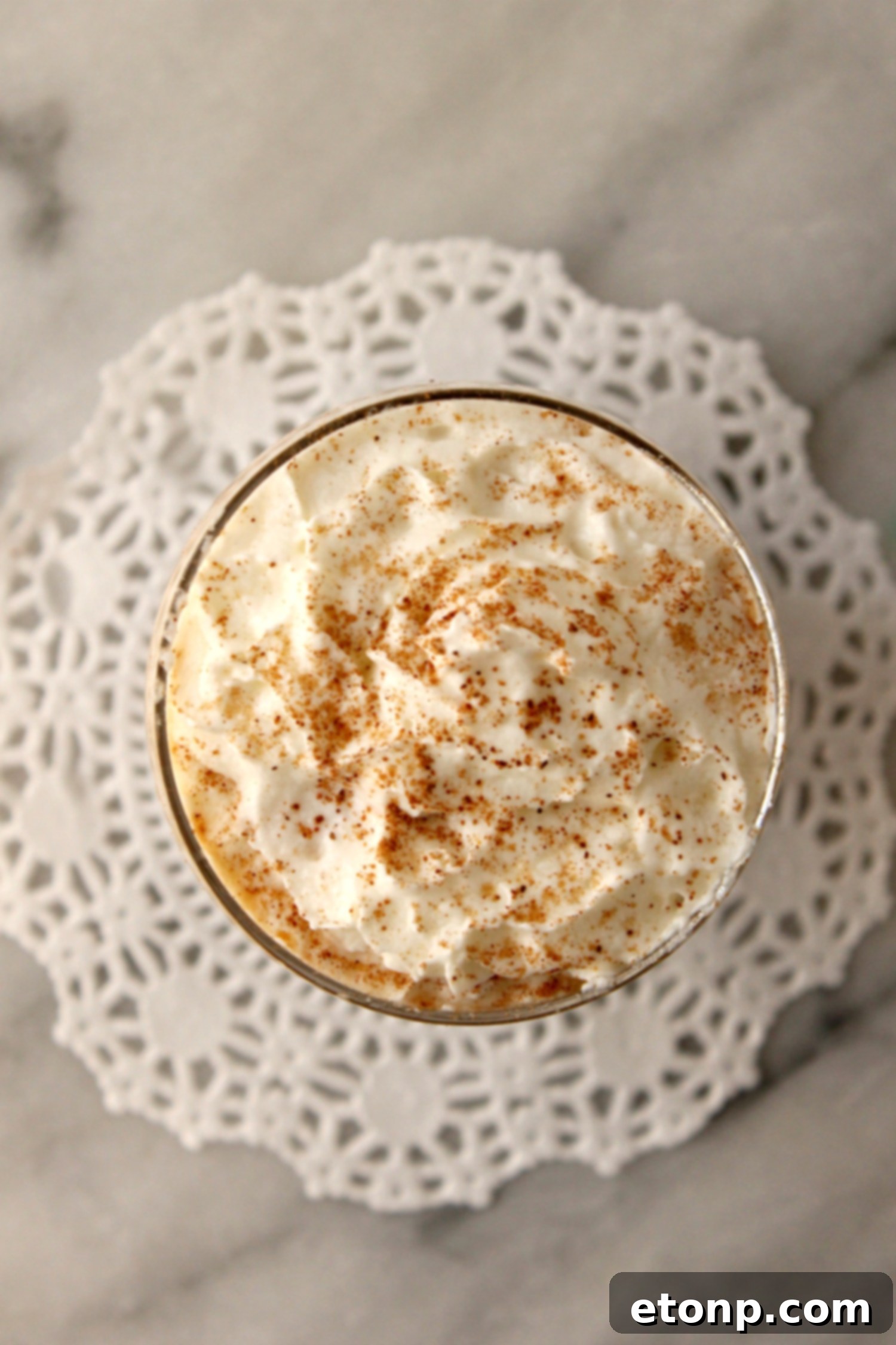 Close-up of the homemade pumpkin spice creamer being poured from a mason jar into a coffee cup, showcasing its rich, creamy texture and inviting color.