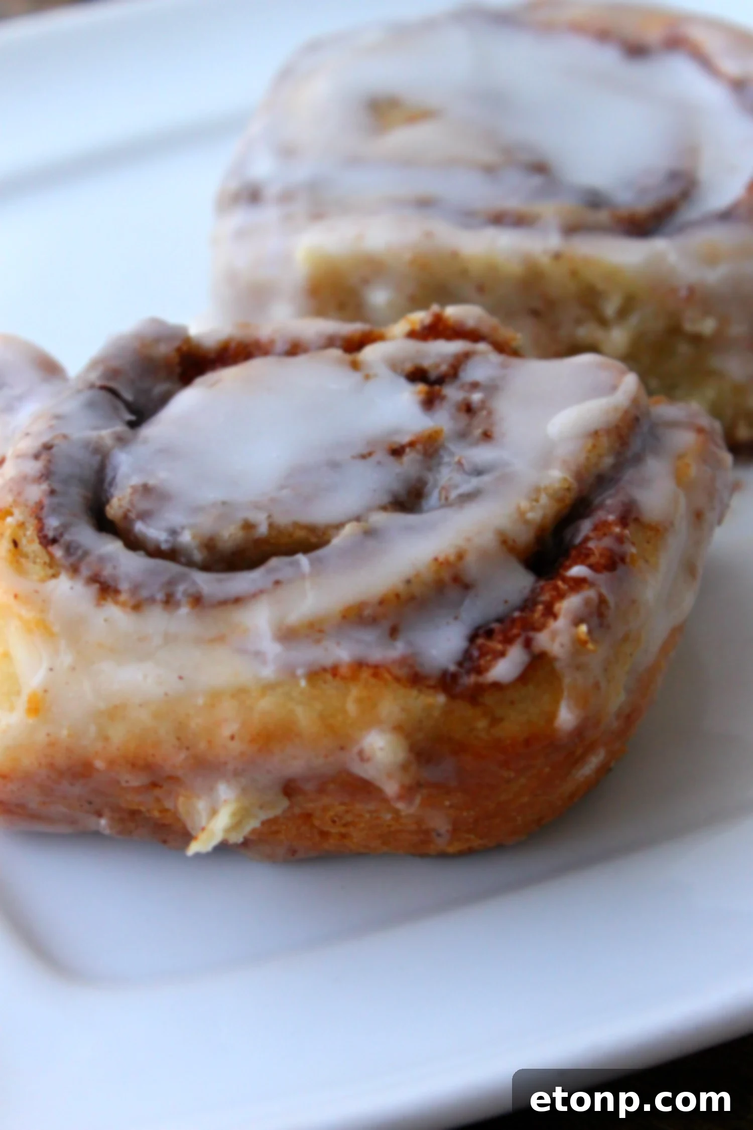 45 Minute Cinnamon Roll Magic 2 Close-up of freshly baked cinnamon rolls with generous white glaze.