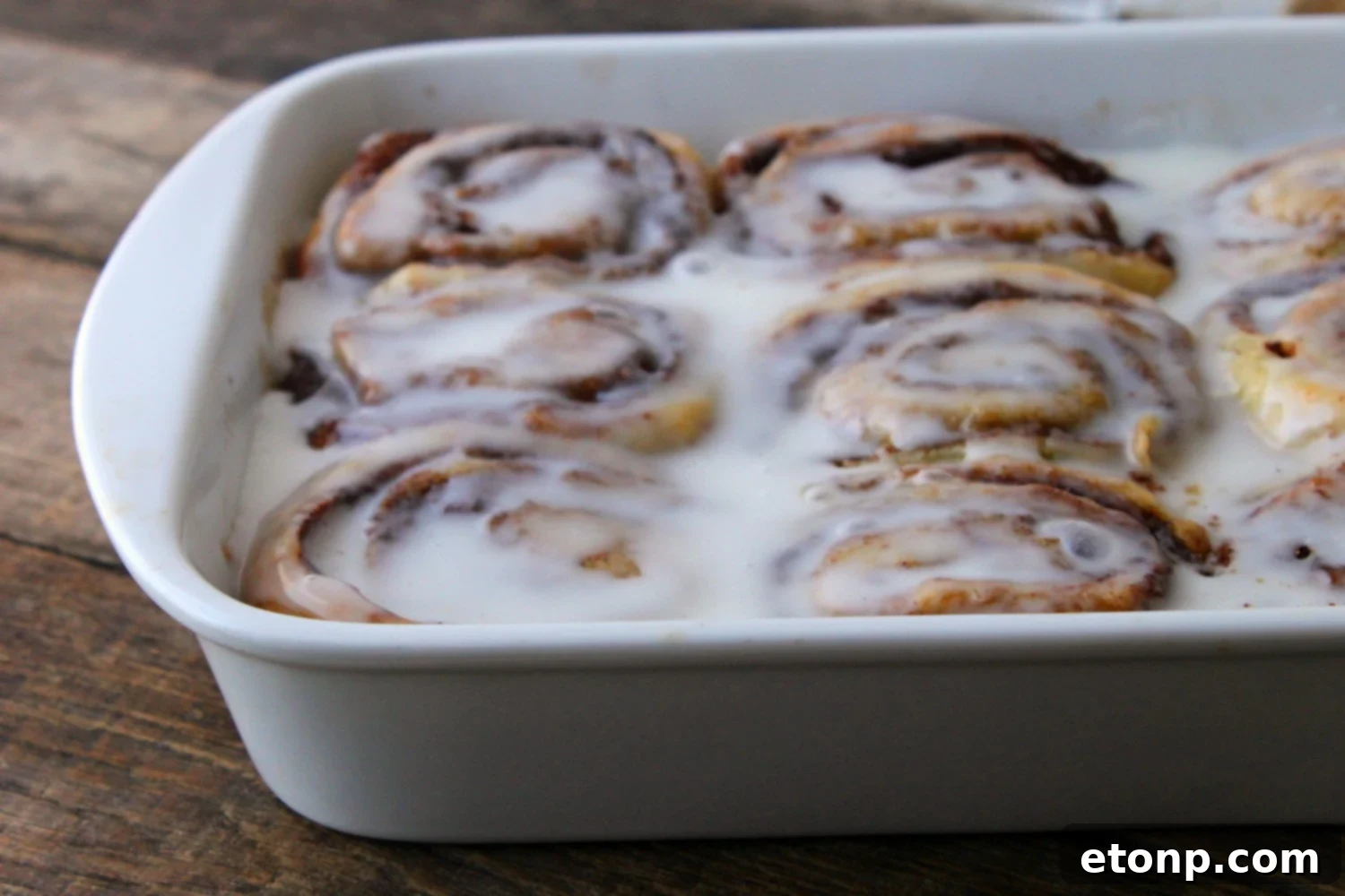 45 Minute Cinnamon Roll Magic 7 Stack of two fluffy, glazed cinnamon rolls on a rustic background.