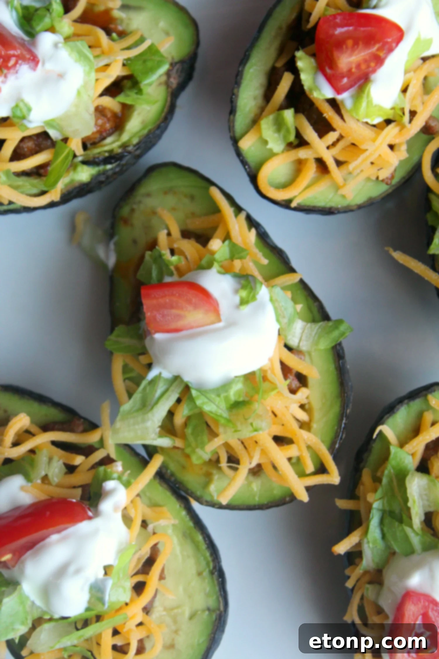 Taco Avocado Boats 4 A selection of Taco Stuffed Avocados, ready to eat, with various toppings, emphasizing their freshness and customizable nature.