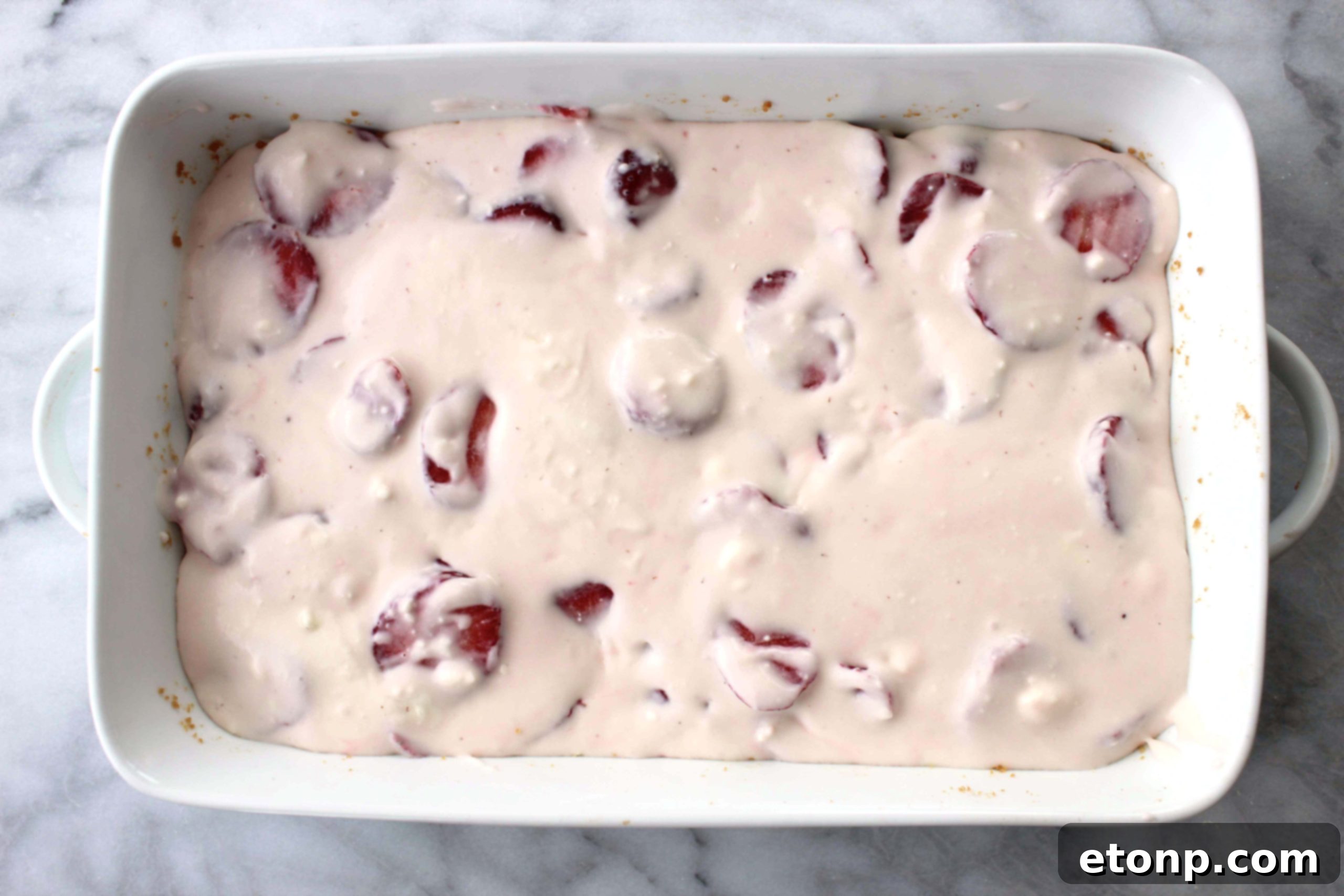 Close-up view of the luscious, creamy strawberry cheesecake filling nestled on the cookie bar base