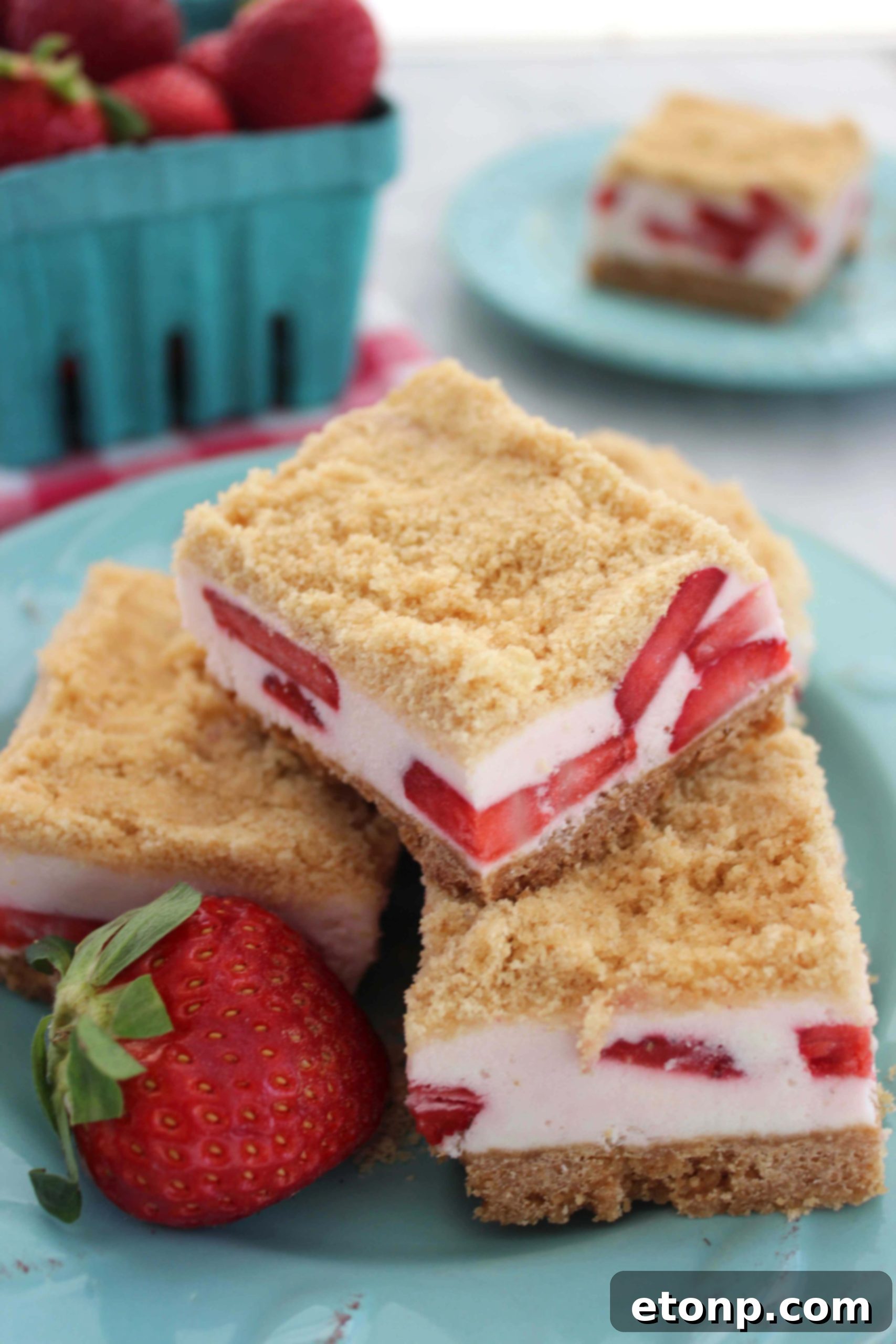 A close-up of a single Strawberry Dream Sugar Cookie Bar, showing the creamy filling and crumbly topping, with a fork poised for a bite