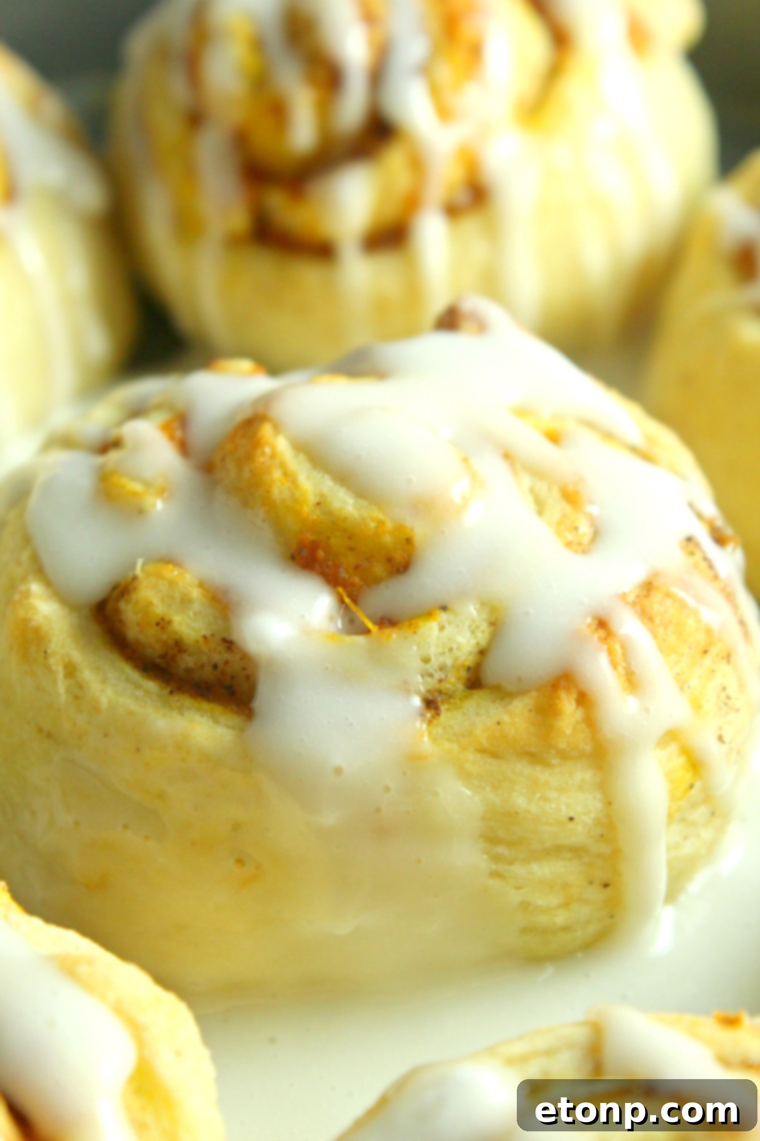 A rustic presentation of warm pumpkin cinnamon rolls, still steaming and inviting, ready to be enjoyed with a cup of coffee.