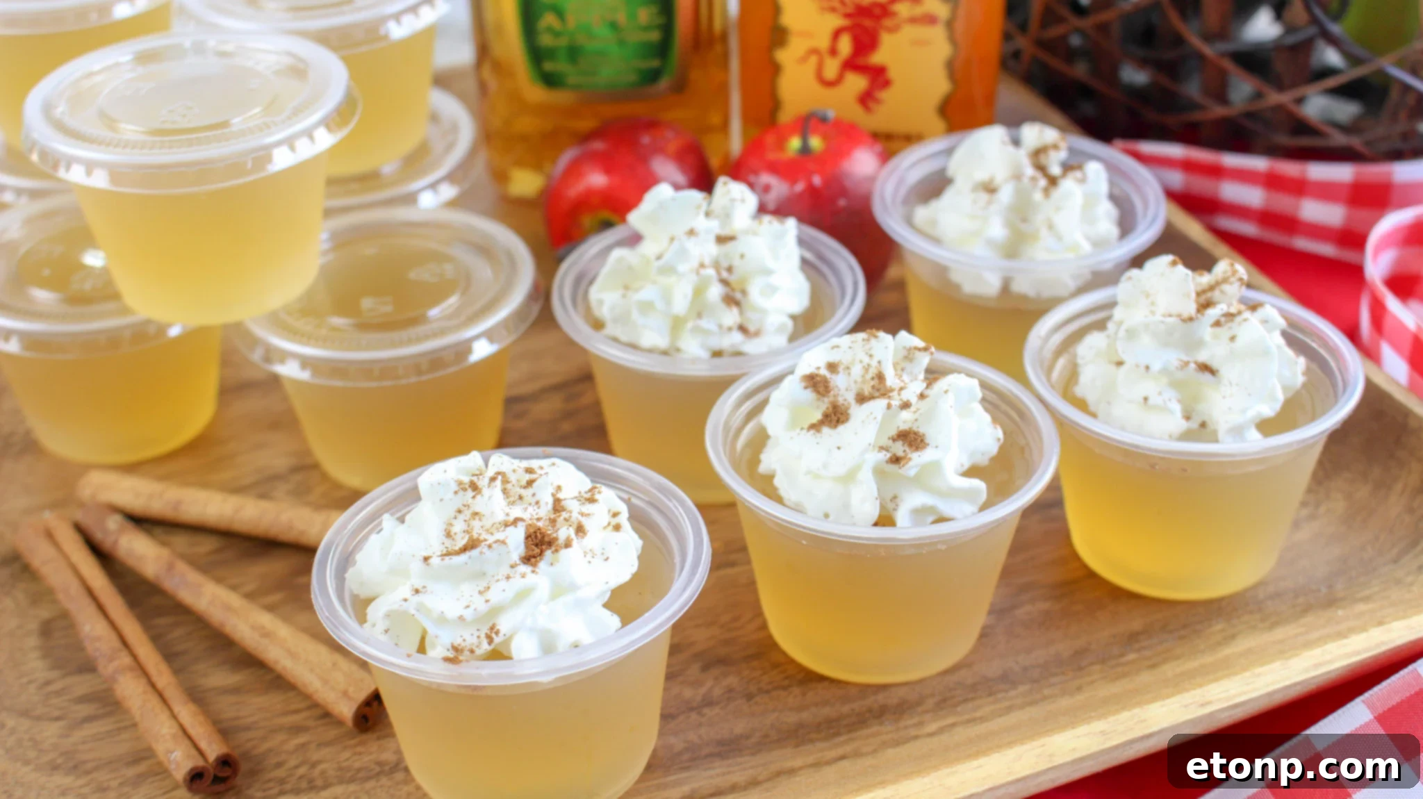 Spiced Apple Pie Shooters 2 Delicious Apple Pie Jello Shots arranged on a rustic wooden tray, ready for a fall party.