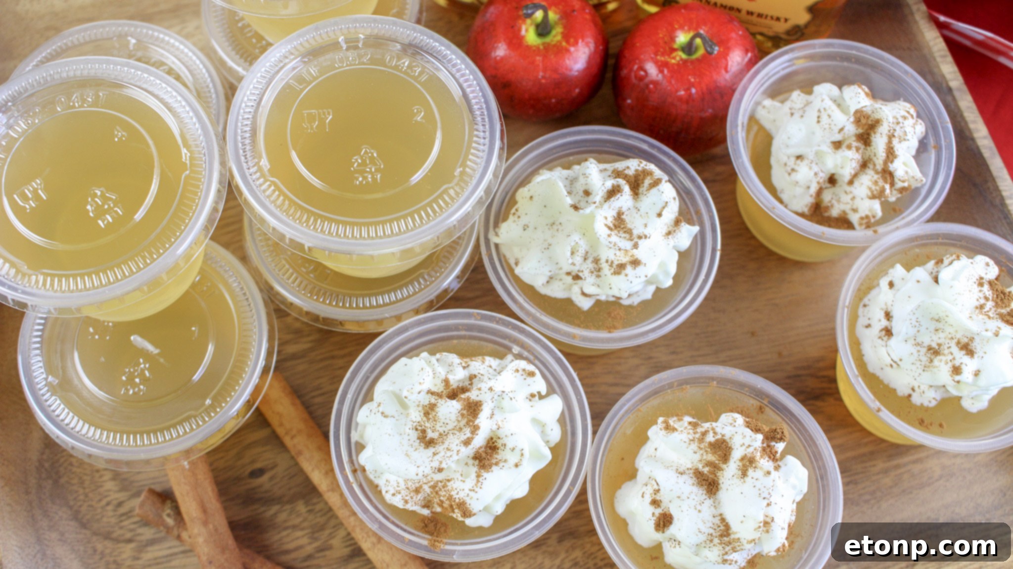 Spiced Apple Pie Shooters 6 A tray full of Apple Pie Jello Shots, some garnished with whipped cream, ready for serving.