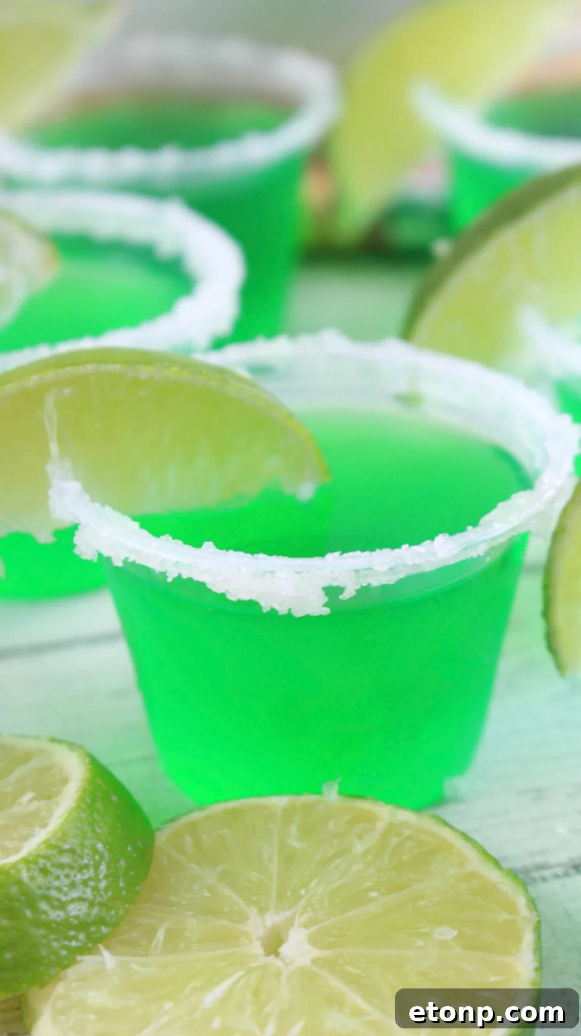 Margarita Jello Shots 2 A tray filled with vibrant green Margarita Jello Shots, perfectly garnished with lime wedges and salt rims, ready for a party.