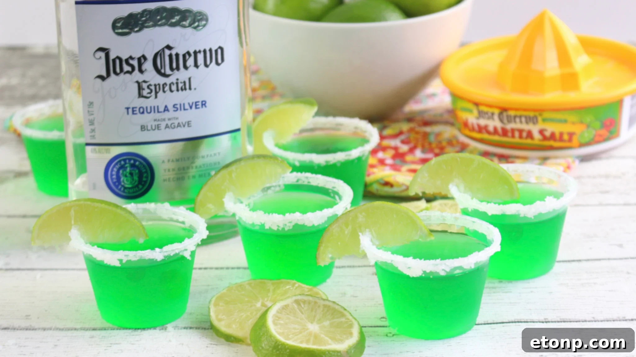 Margarita Jello Shots 6 An array of Margarita Jello Shots arranged aesthetically on a wooden board, garnished with fresh lime wedges, ready for a gathering.