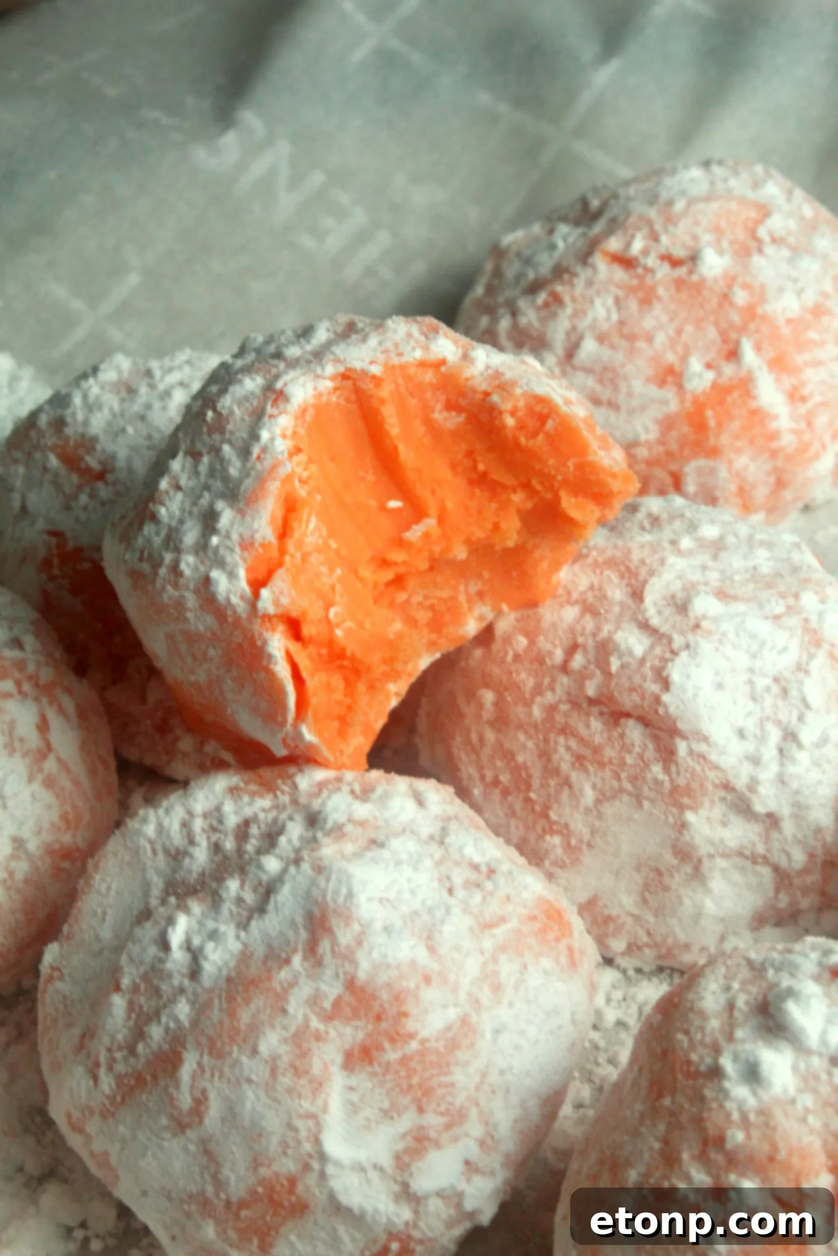 Various Orange Creamsicle Truffles arranged artfully on a white surface, showcasing their vibrant color