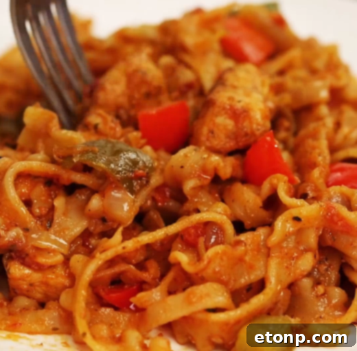 A large serving of chicken fajita pasta with fresh parsley garnish
