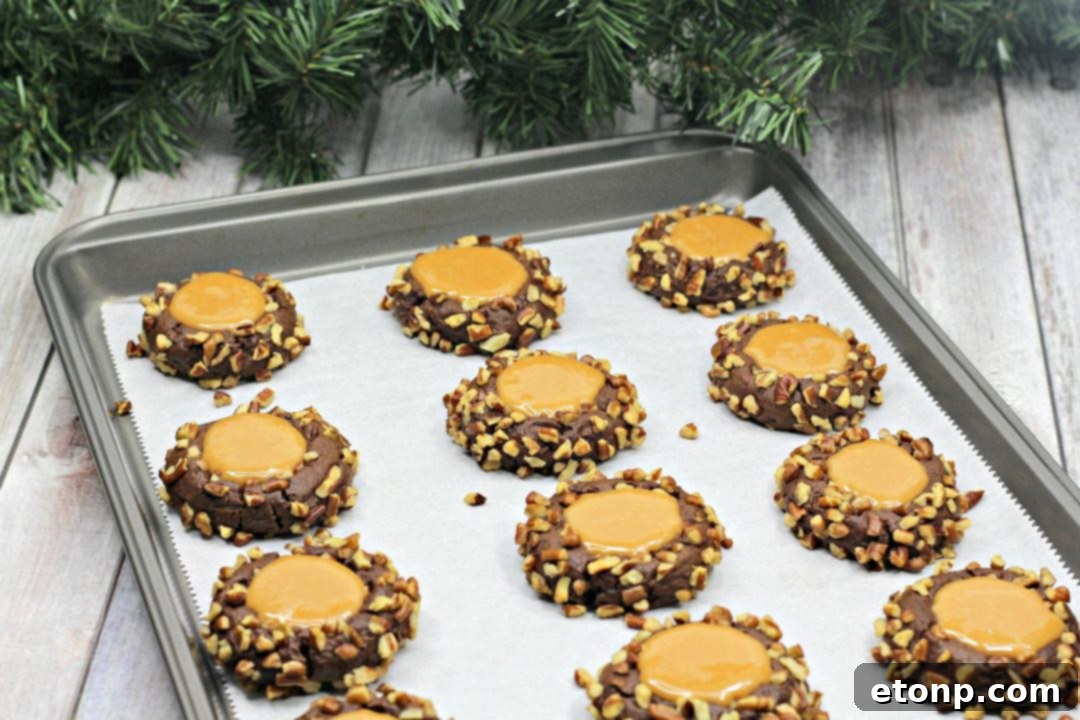 Finished Turtle Thumbprint Cookies with caramel filling in a basket on a wooden table, ready to be enjoyed.