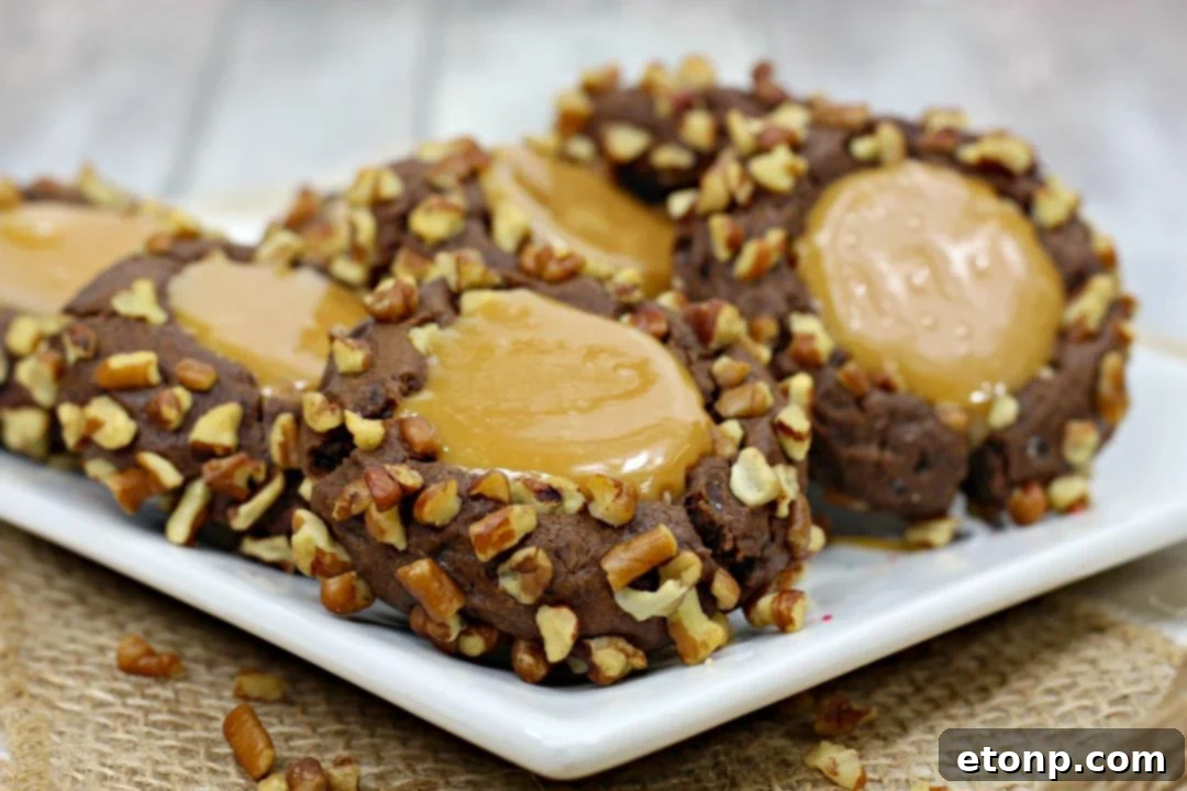 An assortment of Turtle Thumbprint Cookies displayed on a serving platter, highlighting their perfect thumbprint and caramel filling.