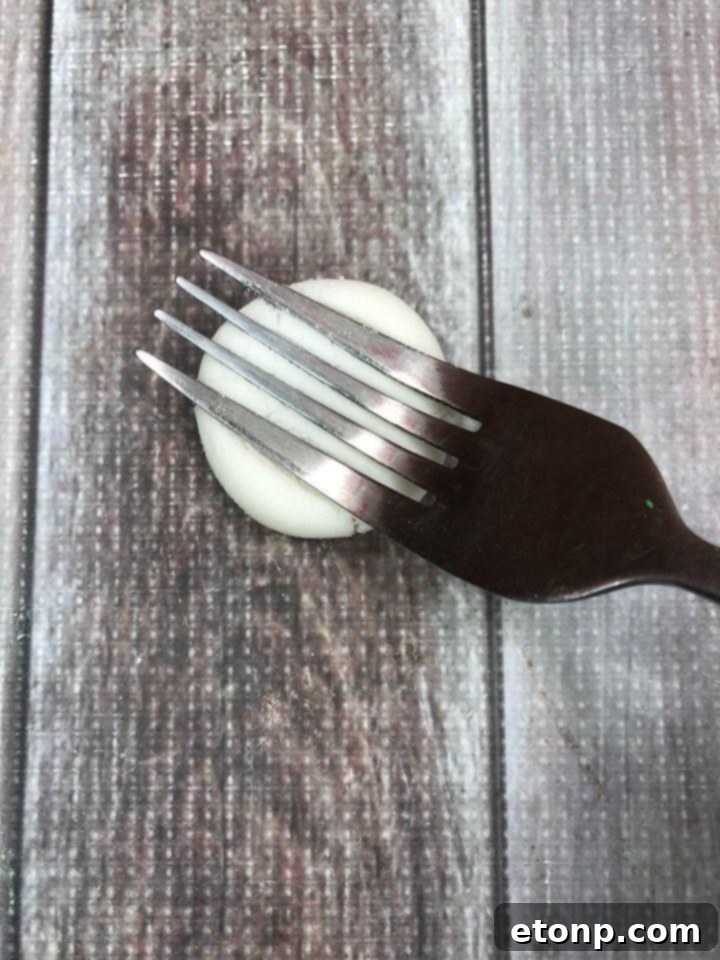 Several flattened, sugar-coated peppermint patties with distinct fork marks, ready to dry.