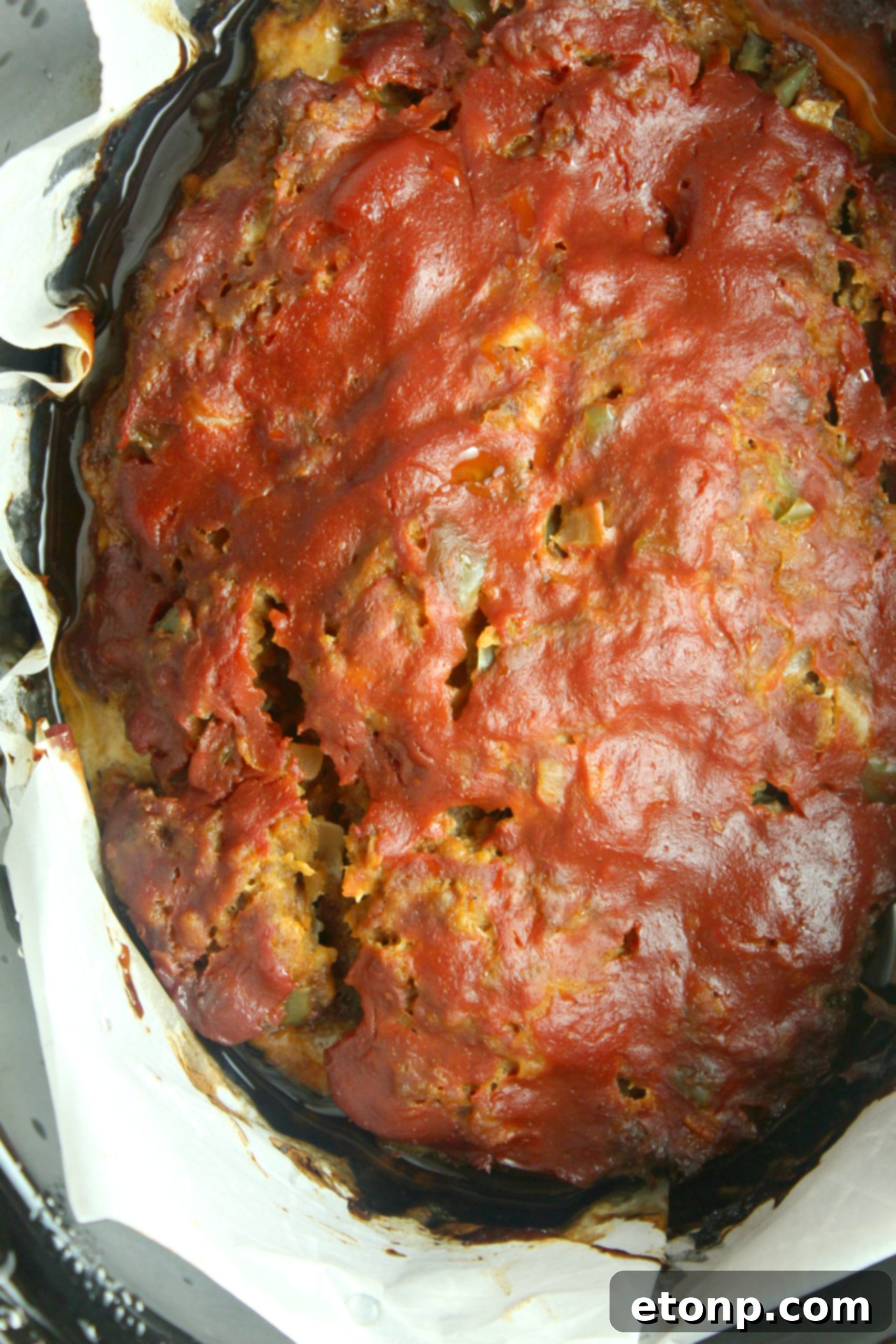 Serving a generous piece of tender slow cooker meatloaf with steam rising.