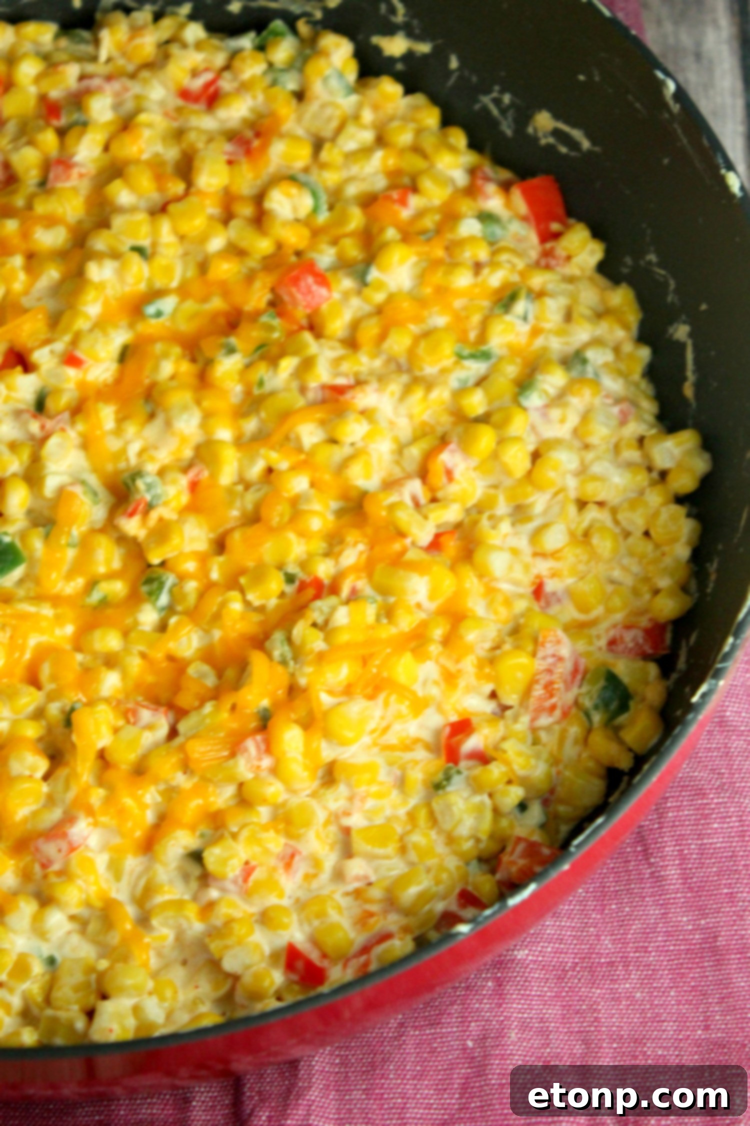Various dippers arranged around a bowl of hot corn dip, including different colored tortilla chips and pita bread.