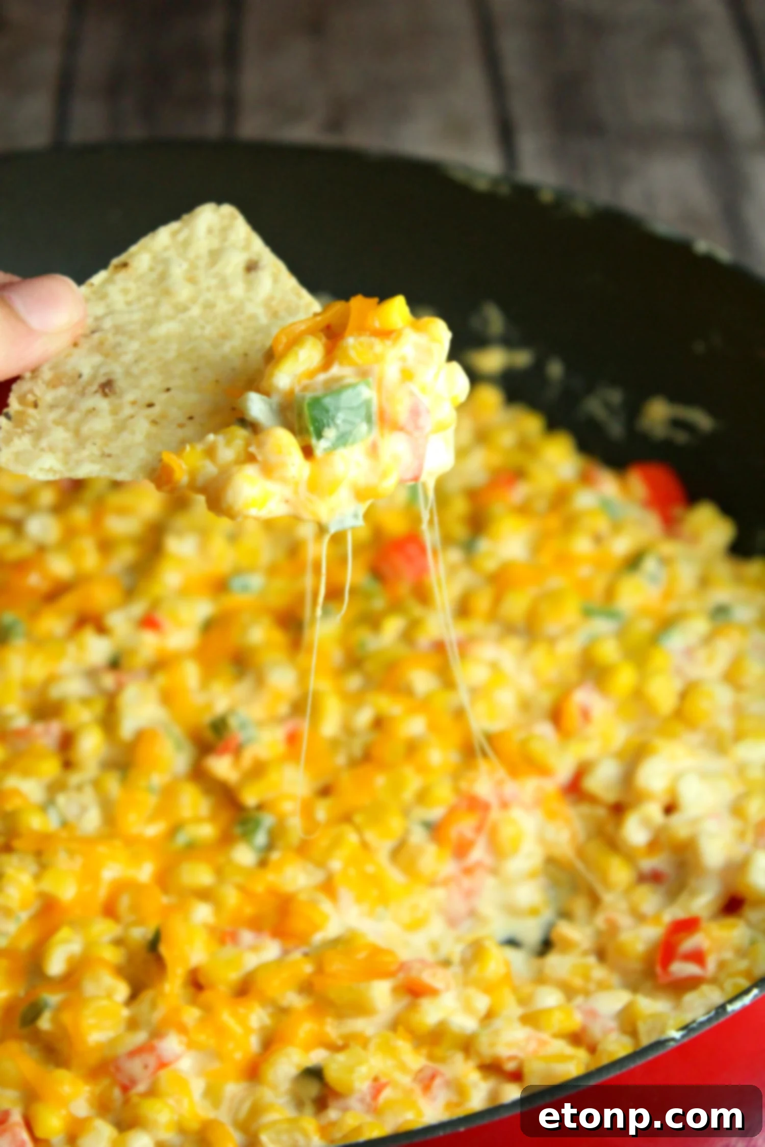Close-up of the hot corn dip, showcasing melted cheese and corn kernels, with steam gently rising.