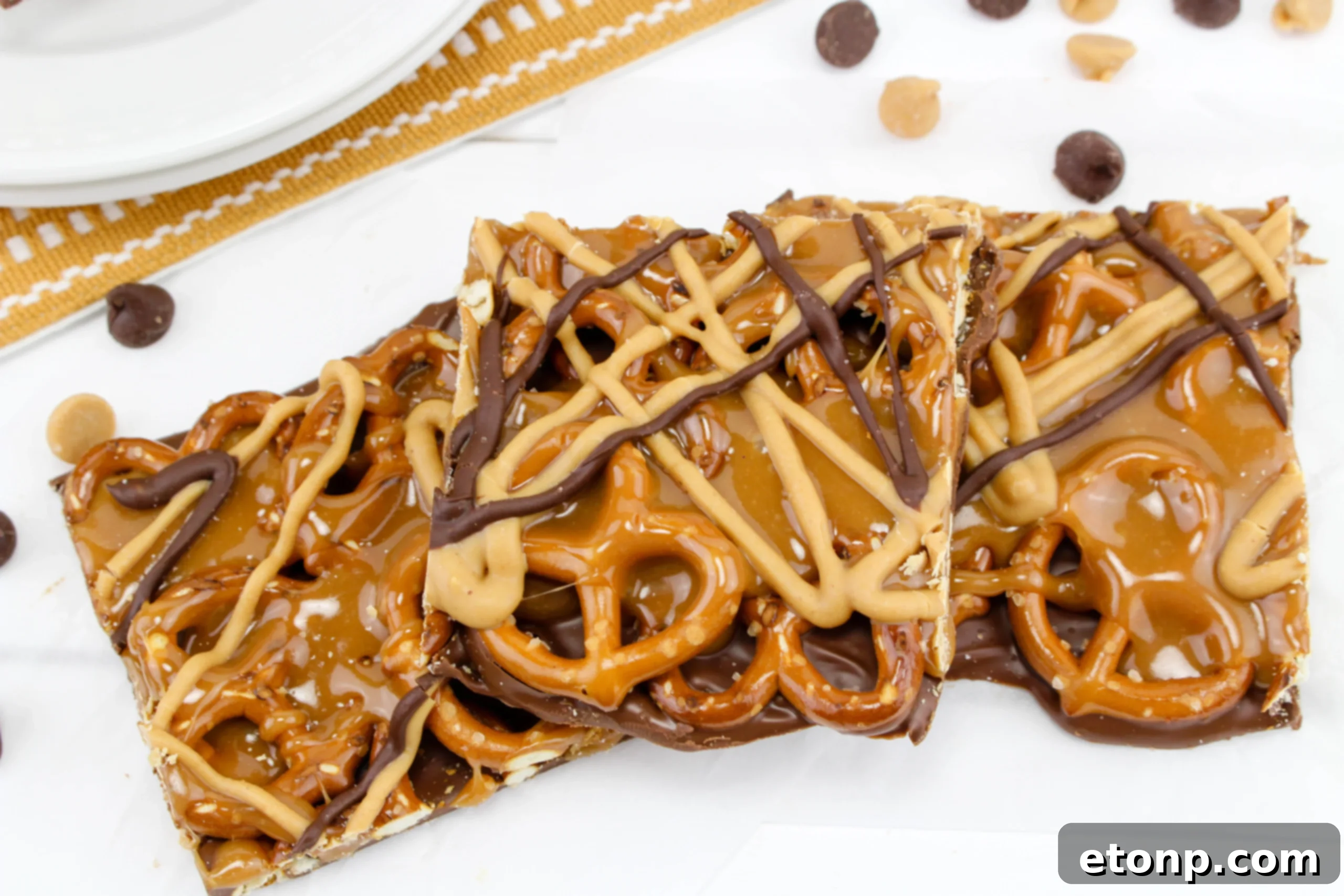 Salty Sweet No-Bake Pretzel Caramel Bars 7 No Bake Caramel Pretzel Crack Bars with a hand reaching for a piece