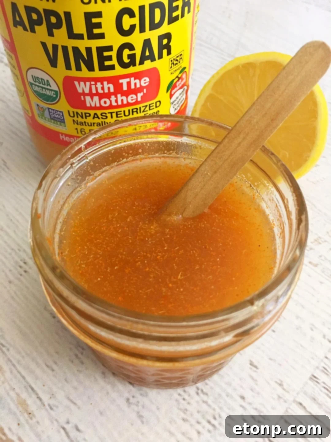 A person gently pouring a spoon of thick, golden homemade cough syrup, showcasing its readiness to provide natural relief.