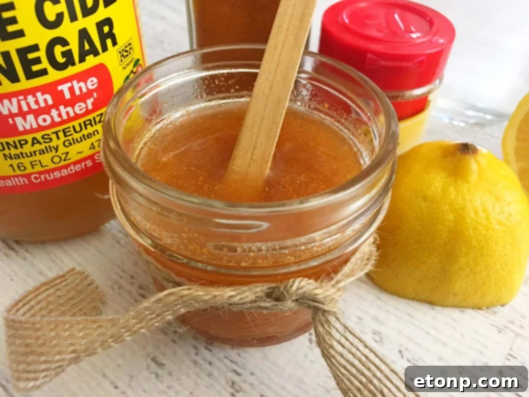 A simple Mason jar filled with the golden homemade cough syrup, ready for use and placed on a clean surface, emphasizing its freshness and accessibility.