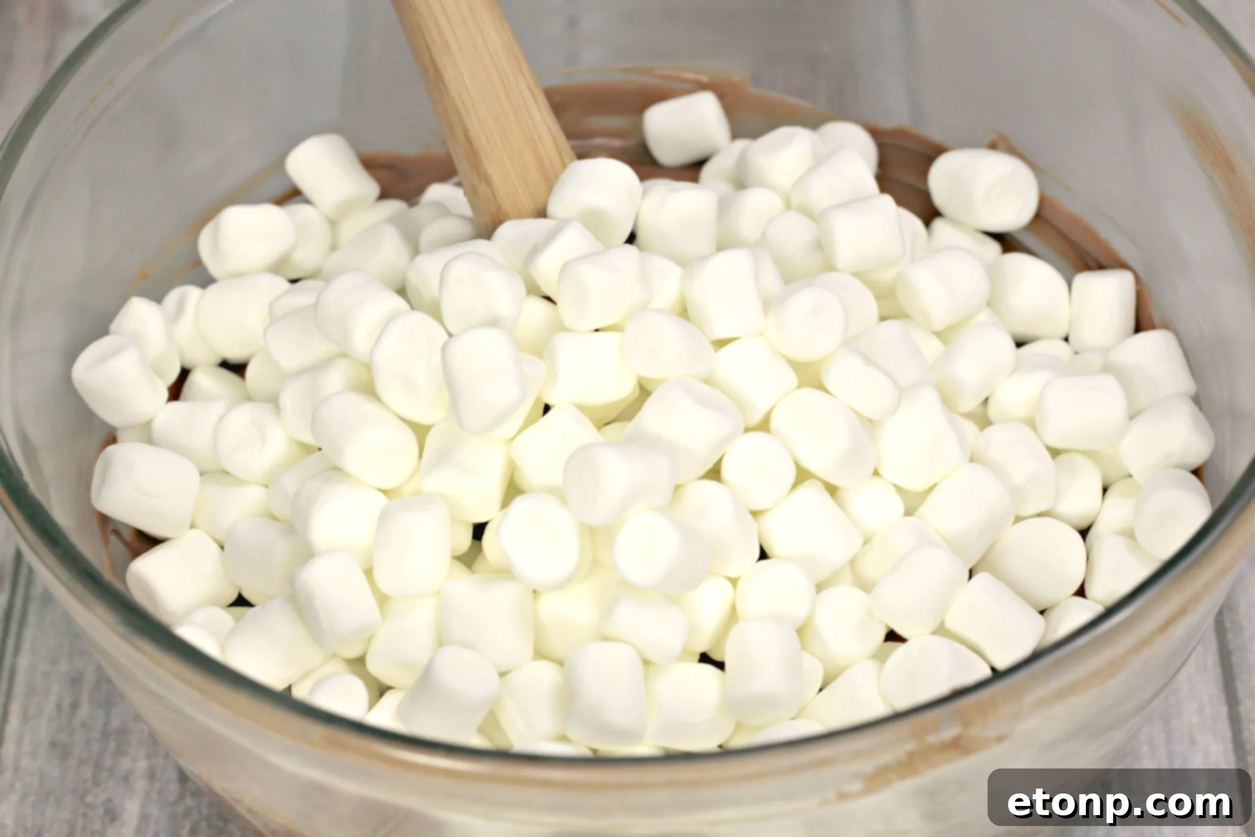 Melted chocolate mixture with mini marshmallows folded in, creating a rich and chewy texture.