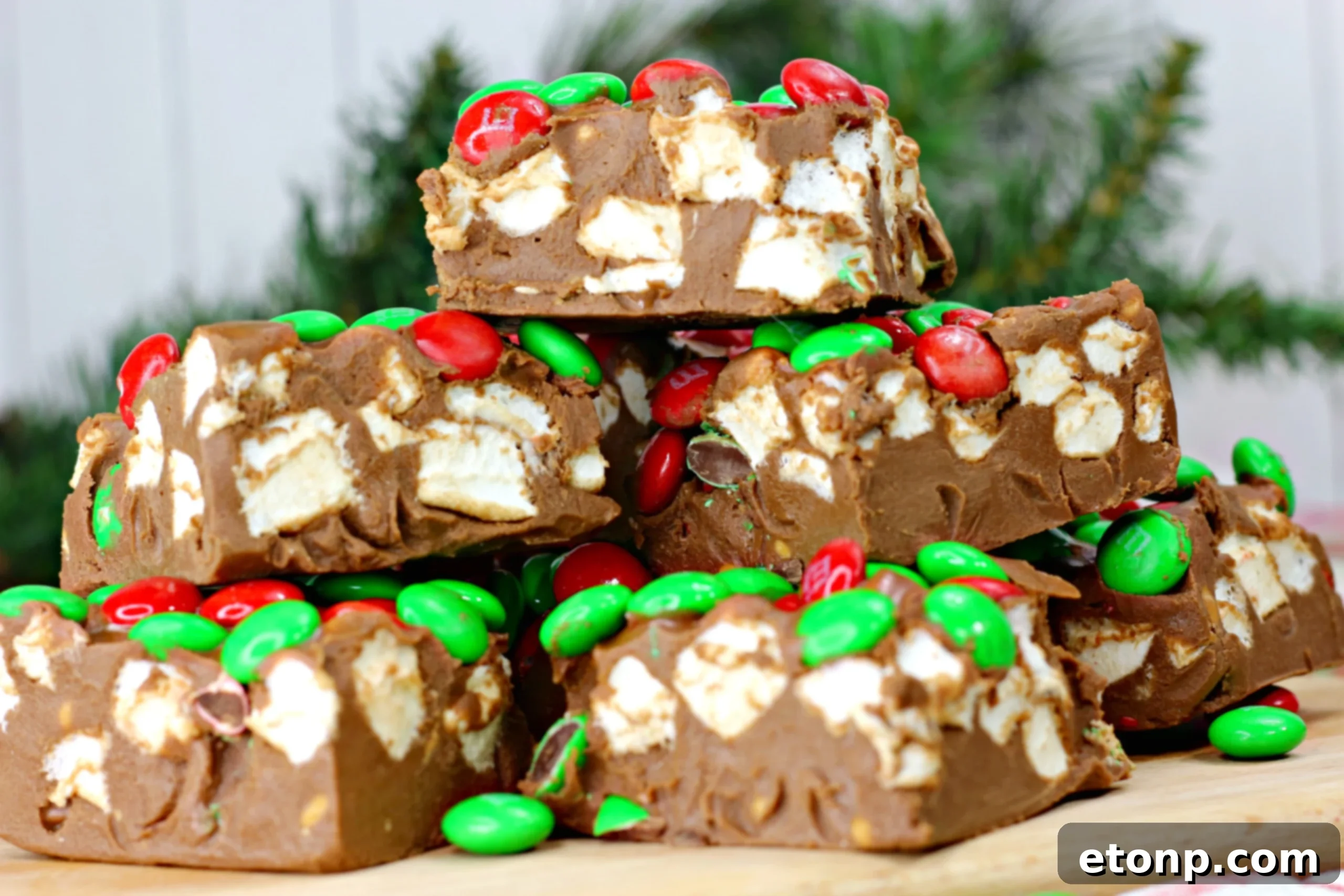 Perfectly cut no-bake holiday marshmallow bars, showing the rich texture and festive M&M's.