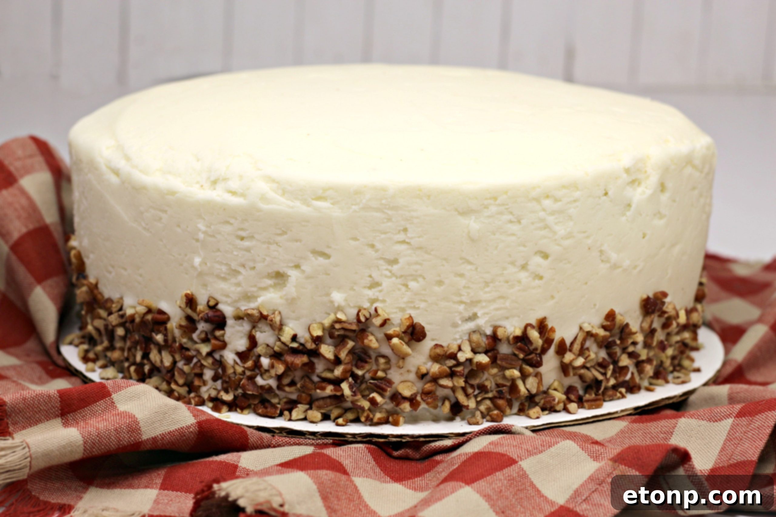 Close-up of a slice of carrot cake showing its moist texture and rich frosting.