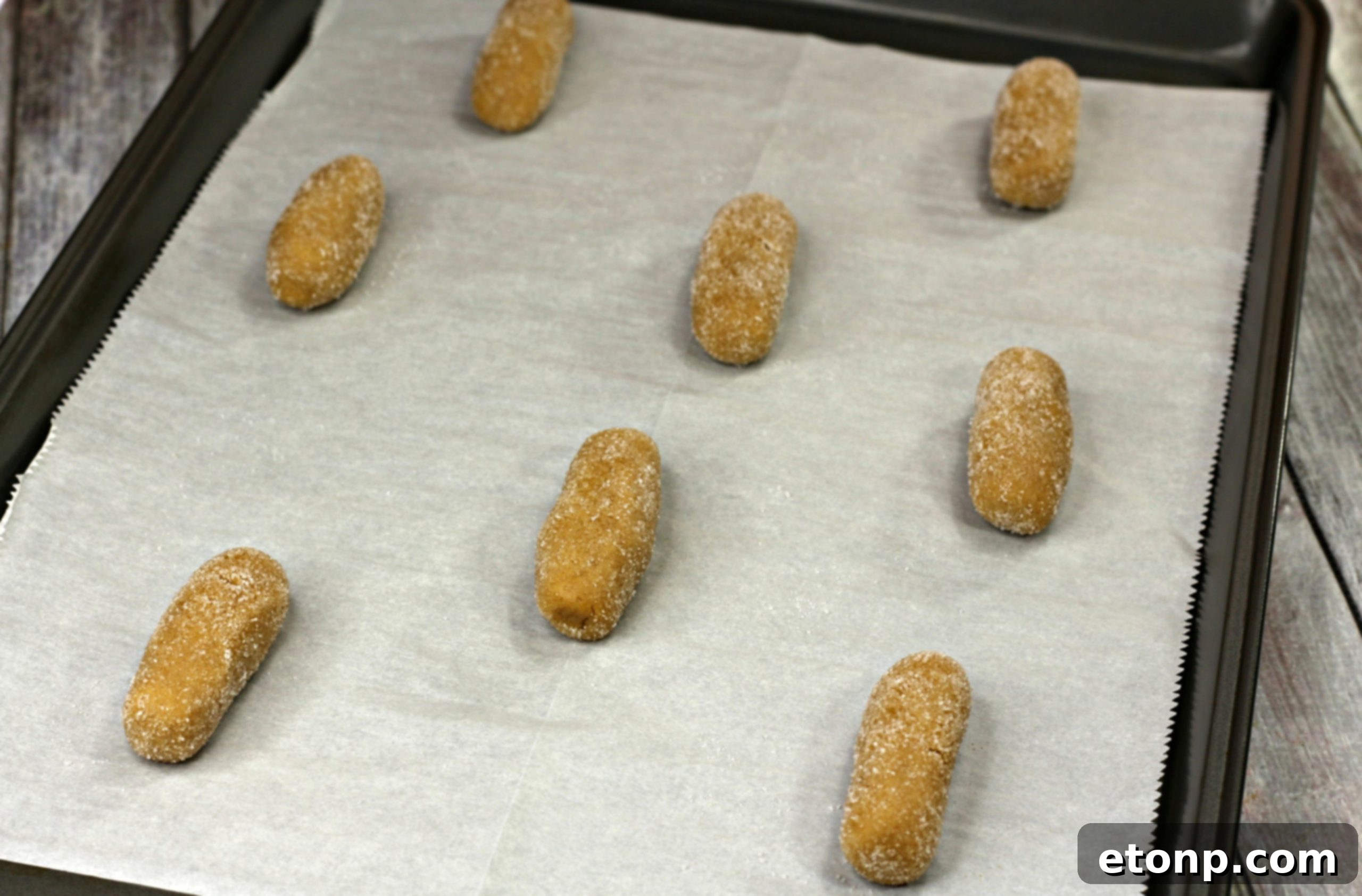 Nutterbutter cookie dough balls evenly spaced on a parchment-lined baking sheet.