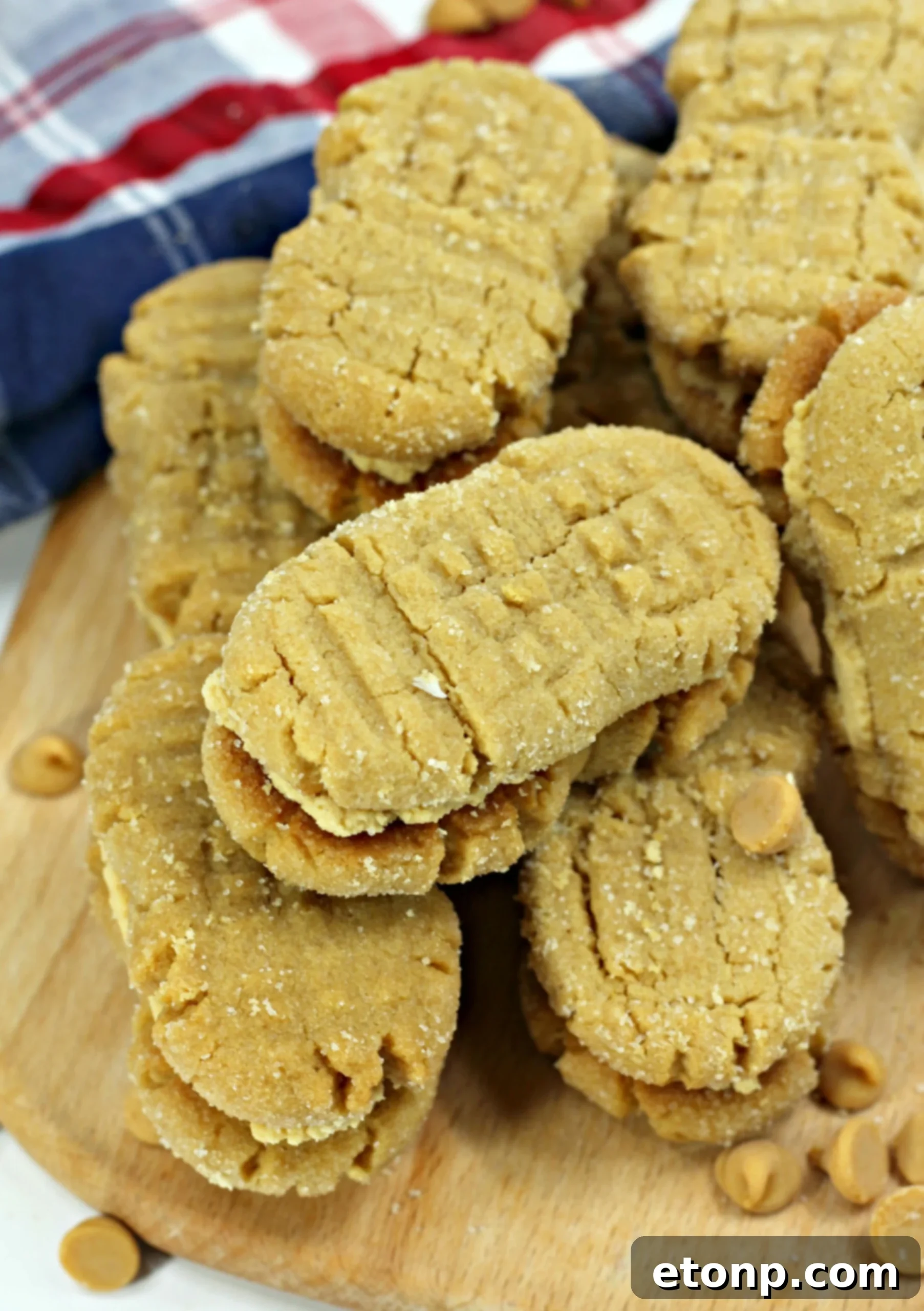 Hands demonstrating shaping Nutterbutter cookie dough into a peanut shape and making fork indentations.