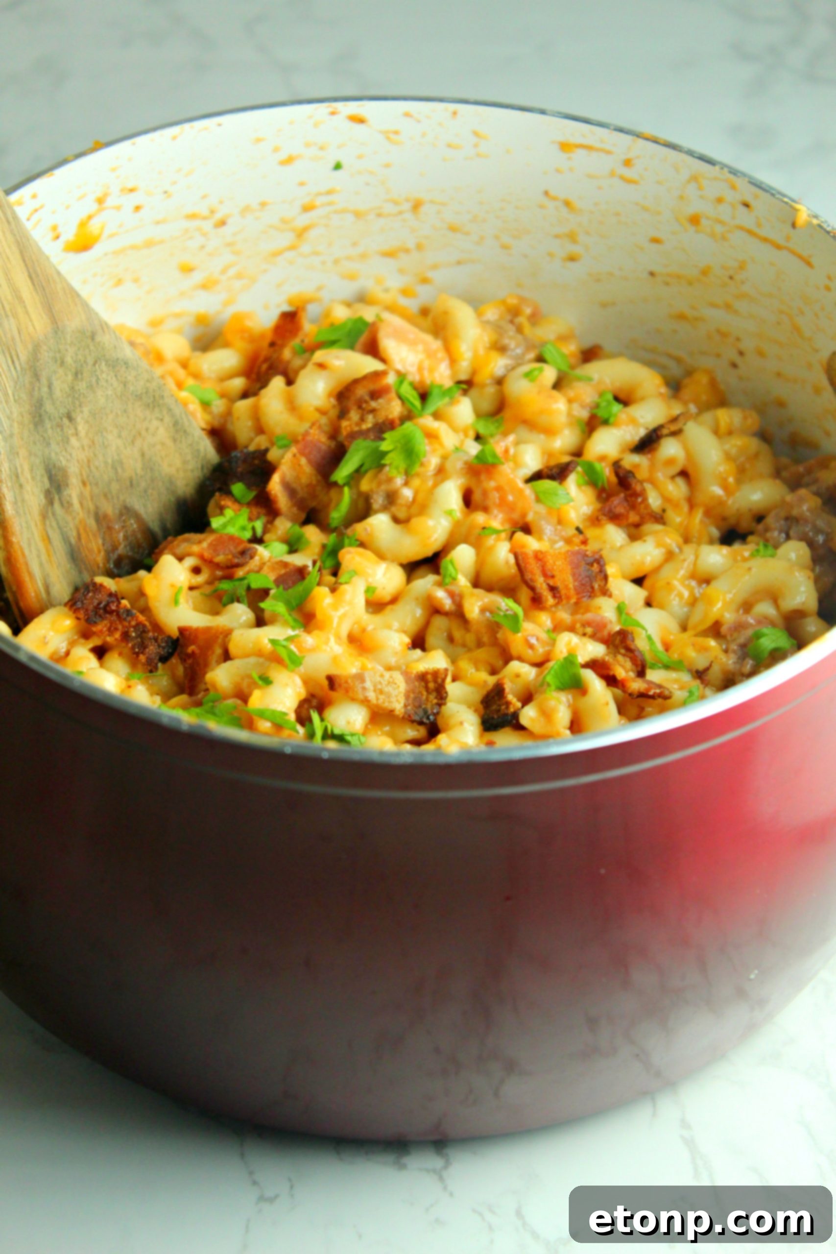 Loaded Ooey Gooey Bacon Cheeseburger Pasta 3 Close-up shot of the gooey, melted cheese on top of the bacon cheeseburger pasta, showcasing its rich texture.