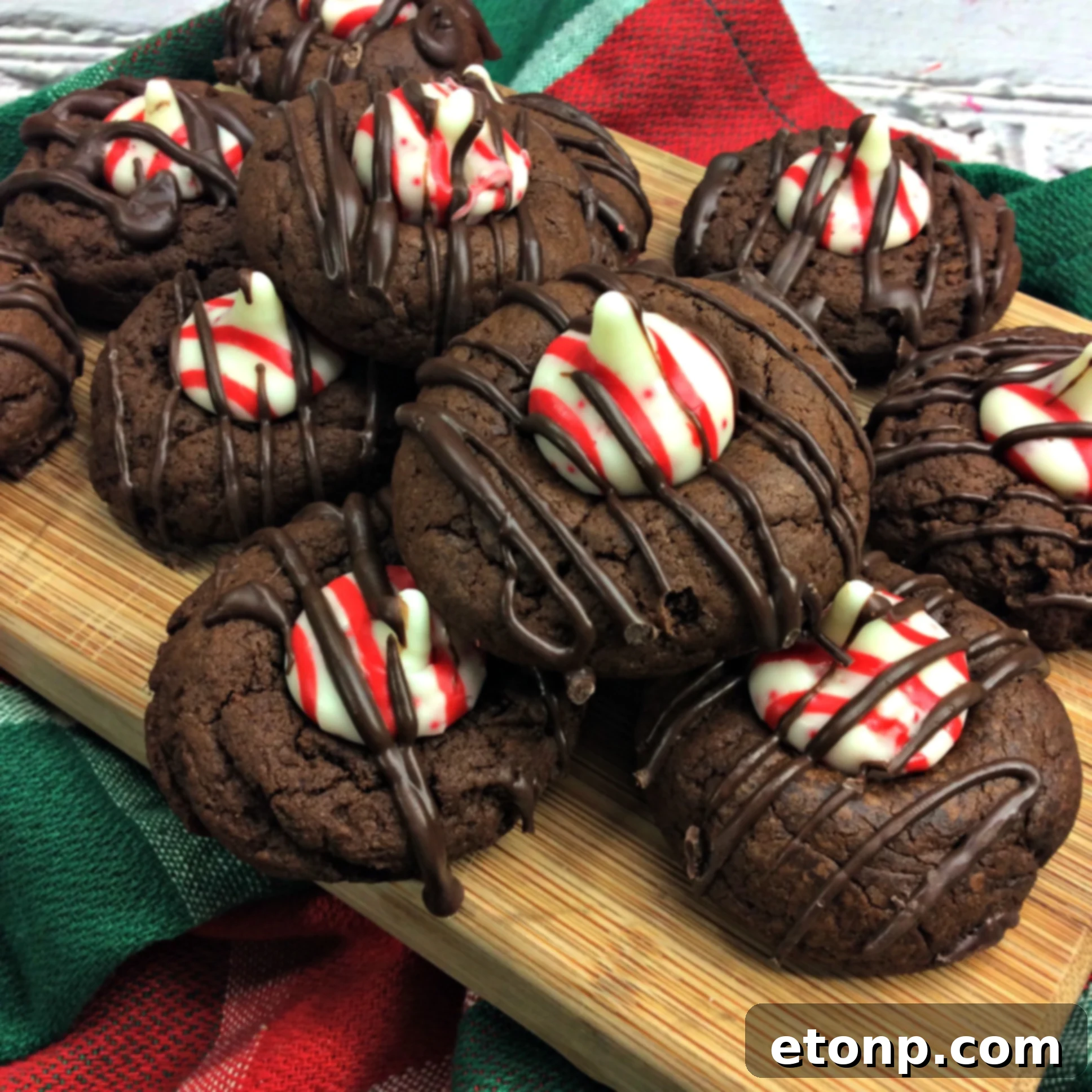 Beautifully arranged chocolate peppermint thumbprint cookies on a festive plate, adorned with a sprig of mint and chocolate drizzle.