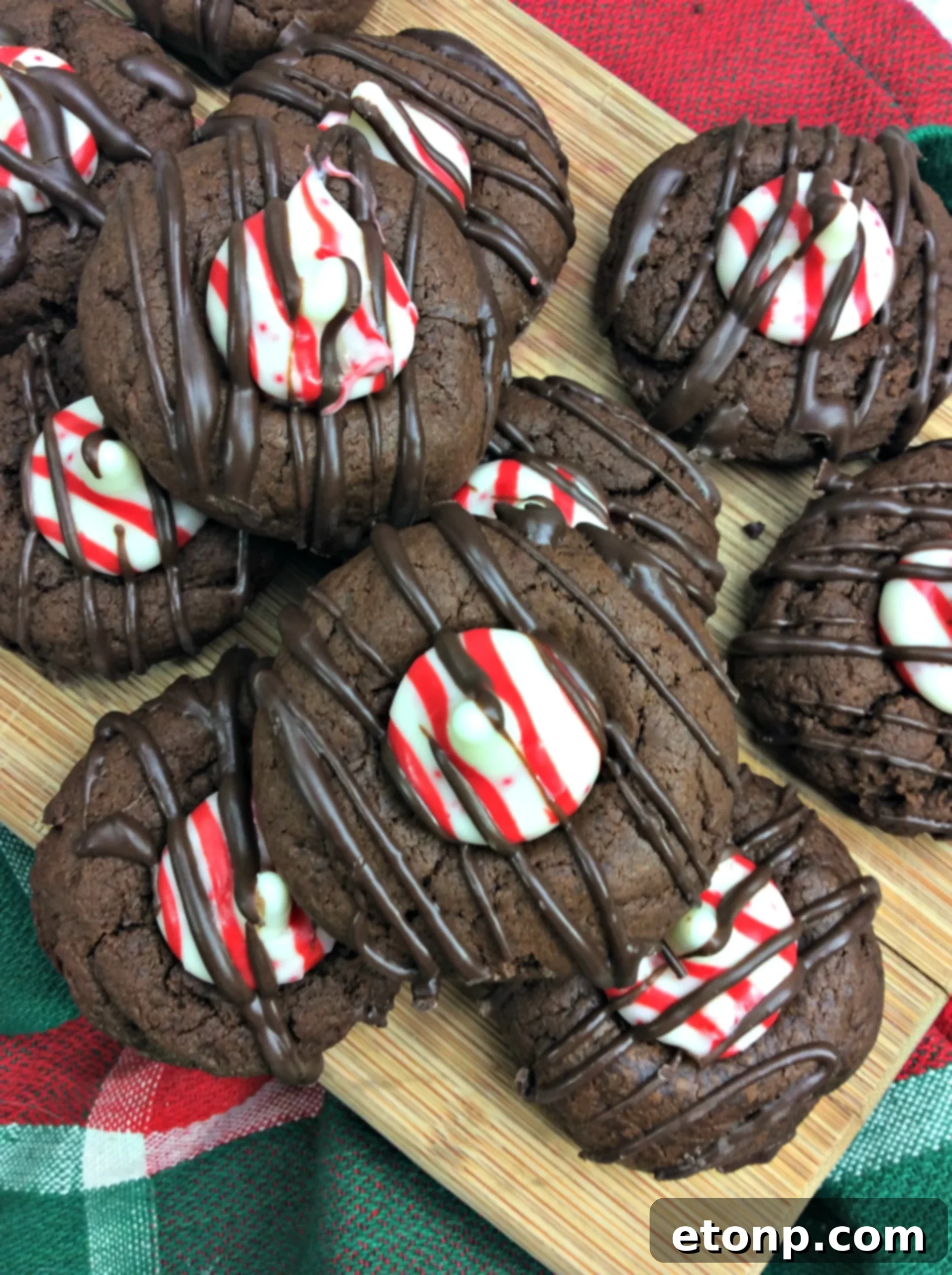 Close-up of a single chocolate peppermint thumbprint cookie, showcasing its soft, chewy center and a melted peppermint kiss.