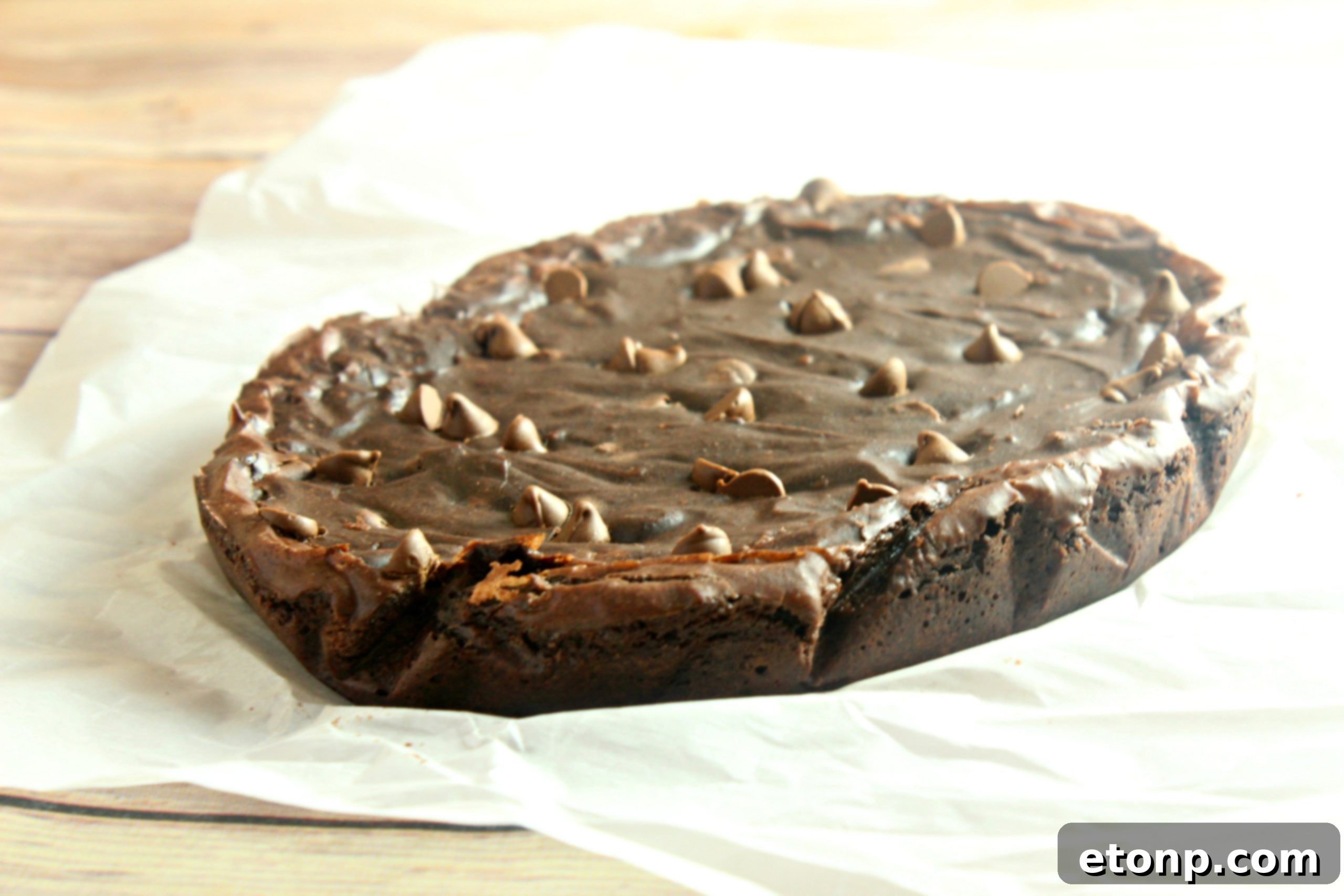 A close-up shot of a warm brownie, generously topped with creamy vanilla ice cream beginning to melt, ready to be enjoyed