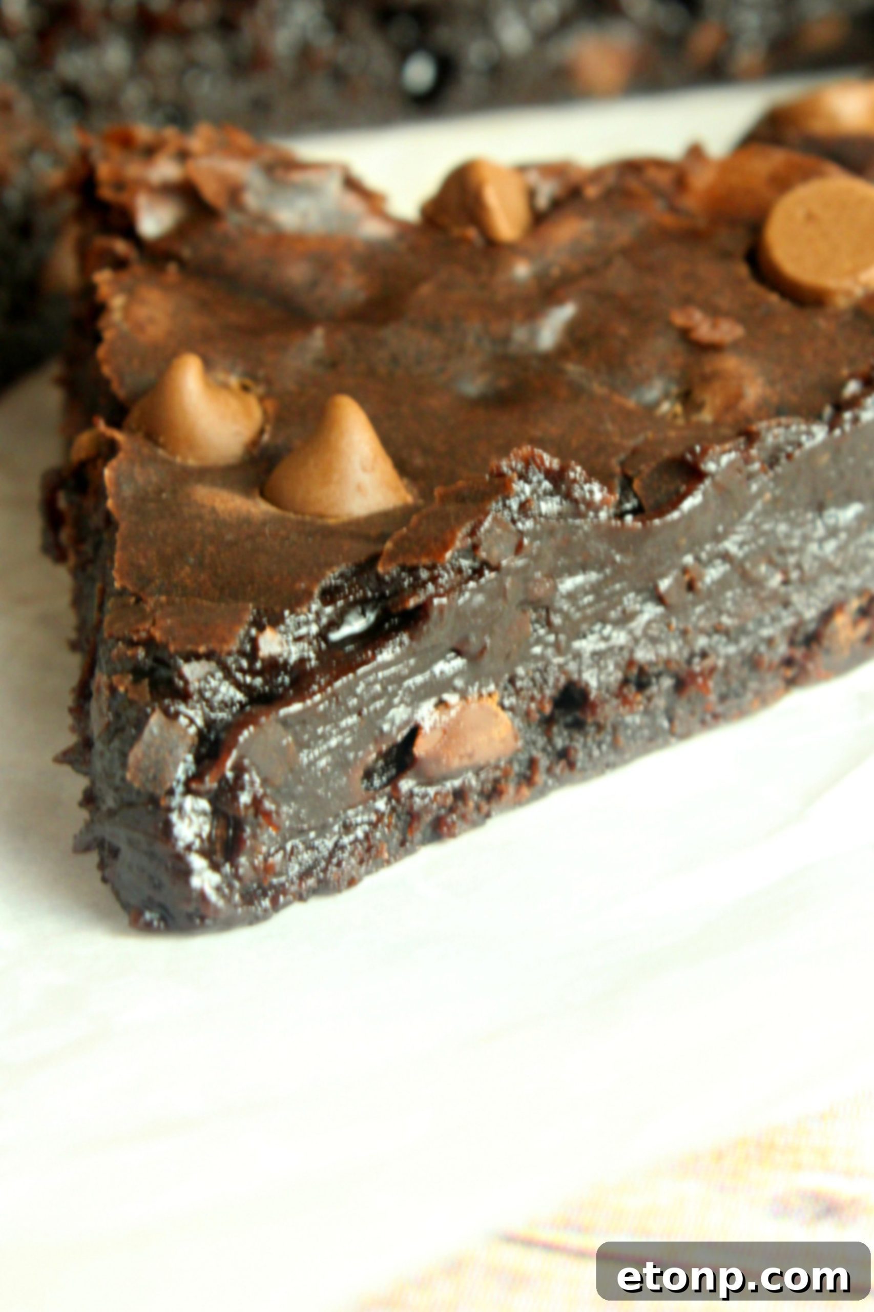 Rich brownie batter being carefully poured into a slow cooker that has been properly lined with parchment paper