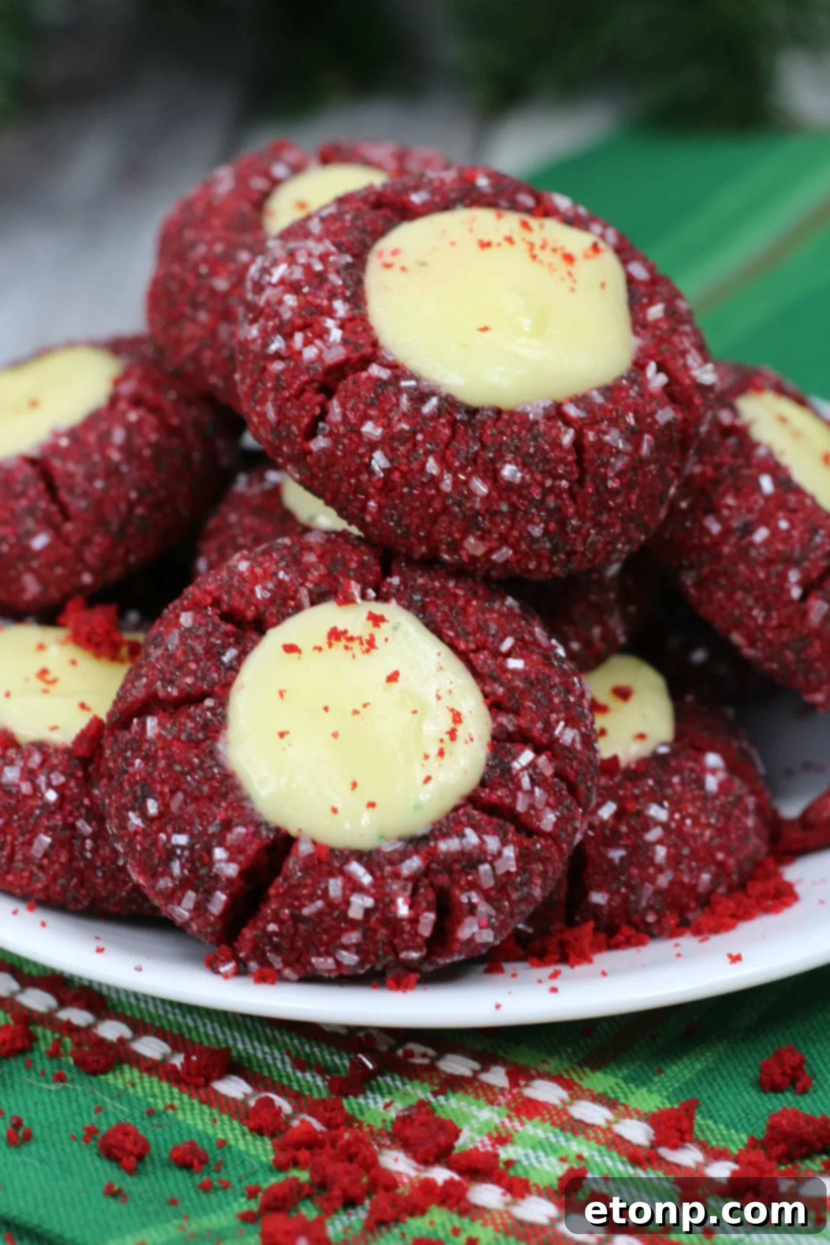 Decadent Red Velvet Cheesecake Thumbprints 7 Red Velvet Cheesecake Cookies on a wooden board, highlighting their festive and indulgent nature.