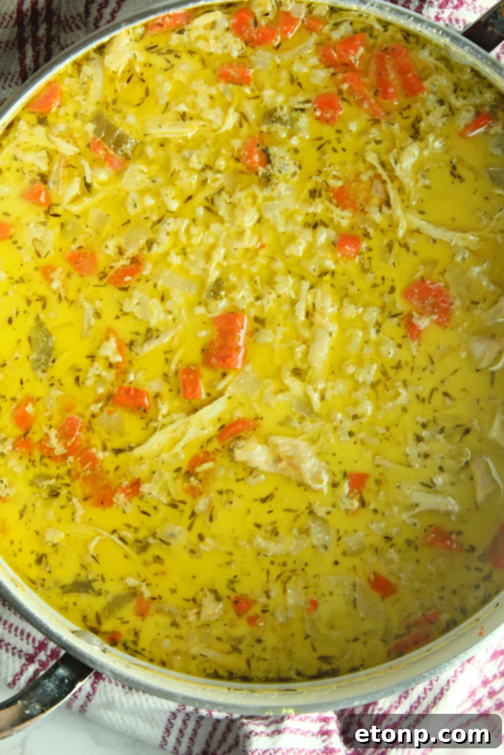 Easy Chicken and Rice Soup 8 Another perspective of chicken and rice soup in a bowl, with a spoon resting in it.